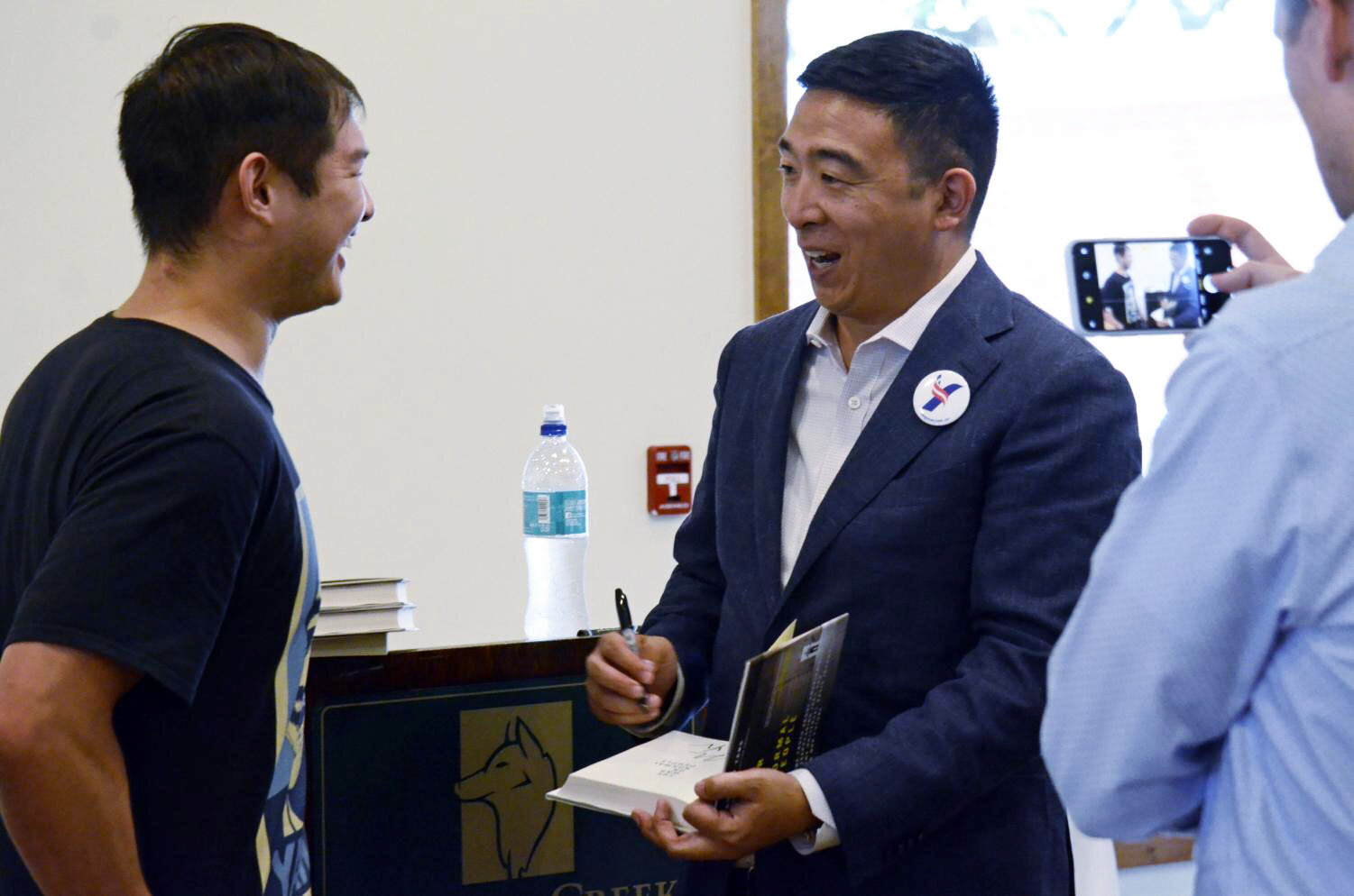 Andrew Yang signs the inside cover of his 2018 book “The War on Normal People," gifting it to a supporter. In 2015, Yang was recognized as a Presidential Ambassador for Global Entrepreneurship by then-president Barack Obama. Photo by Eric Fang