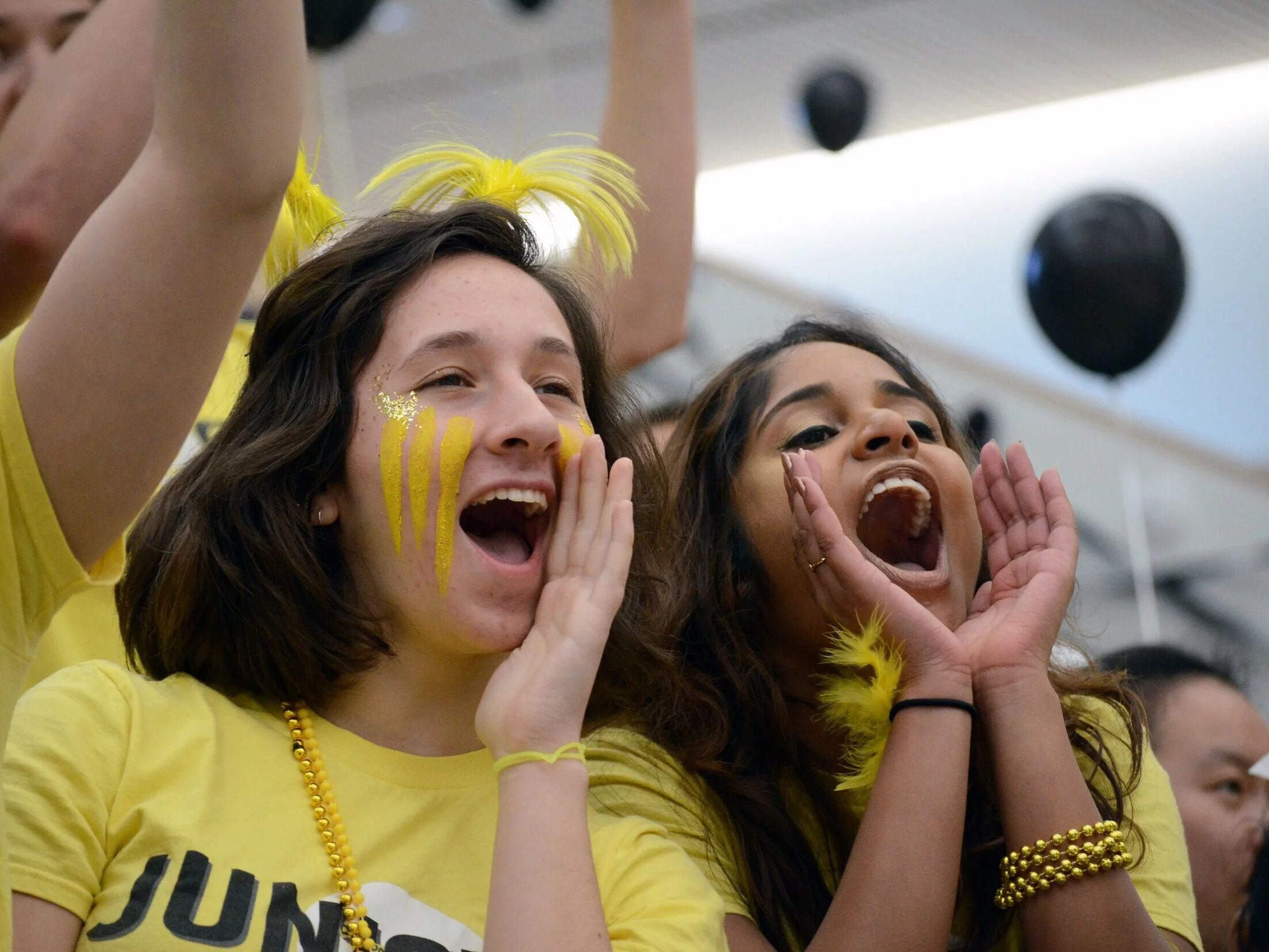 Two juniors cheer on their classmates while they compete in a drag race. The sophomore class’s class color is yellow. Photo by Eric Fang