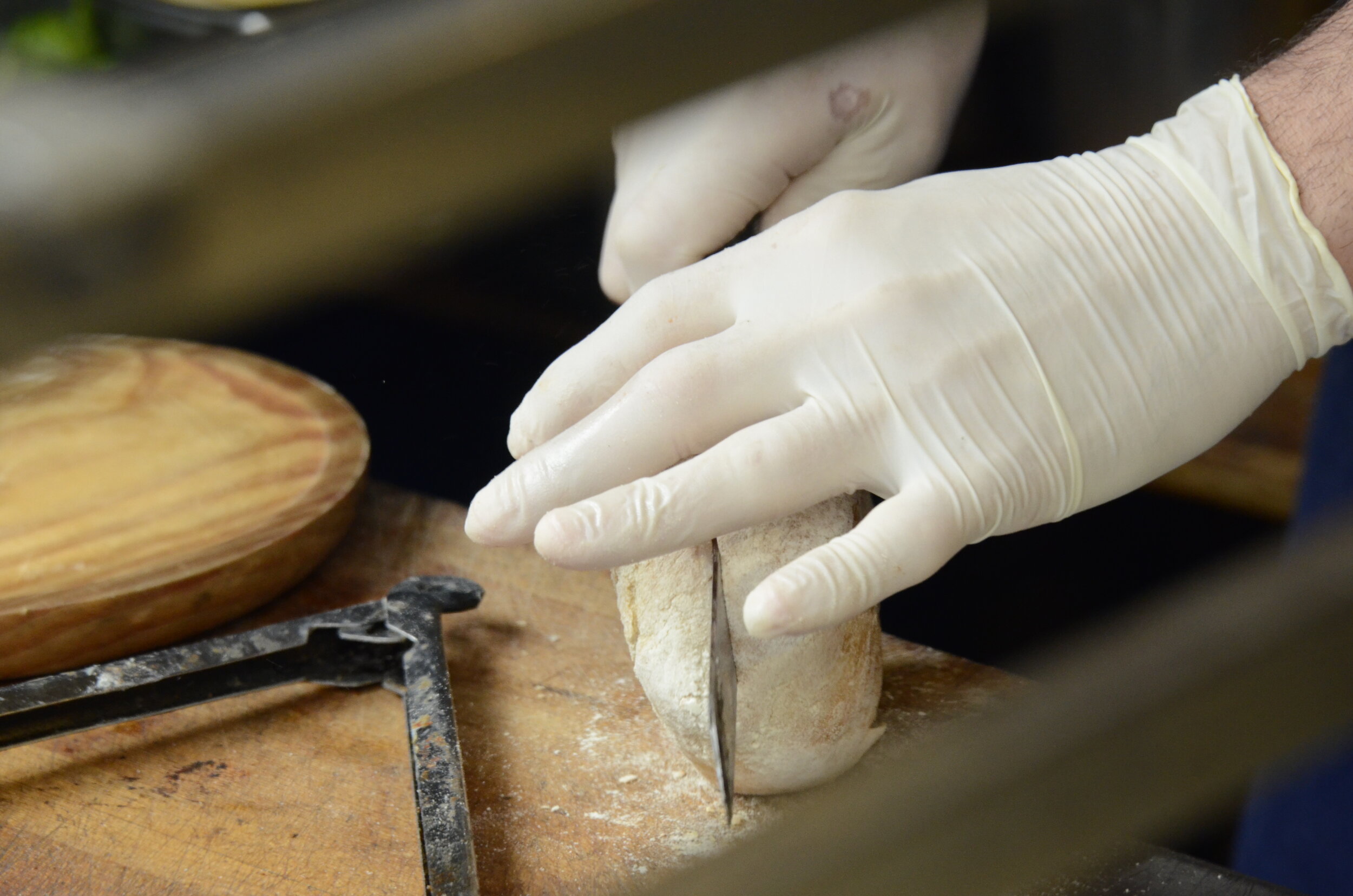 A chef cuts bread at Borough Market in London on June 12, 2019. Photo by Eric Fang