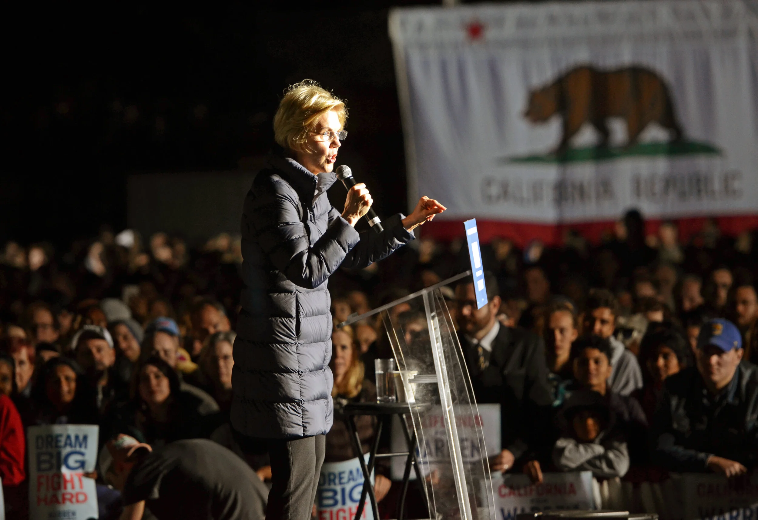 Warren speaks about tackling income inequality with a California flag in the background. To address wealth inequality and help fund her reforms,&nbsp;Warren&nbsp;proposed a two-cent tax, or a two percent tax on assets over $50 million. Photo by Eric…
