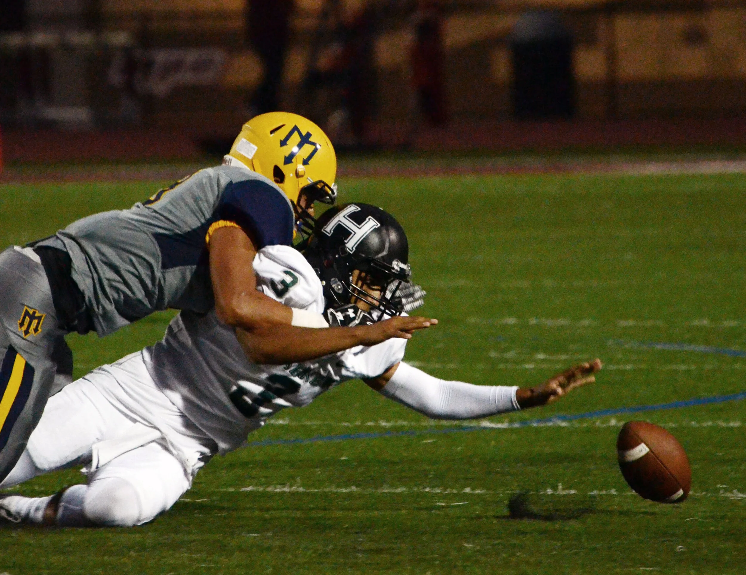The Harker varsity football team quarterback fumbles the ball behind the offensive line. The varsity football team ended their 2017-2018 season with an 11-1 record. Photo by Eric Fang