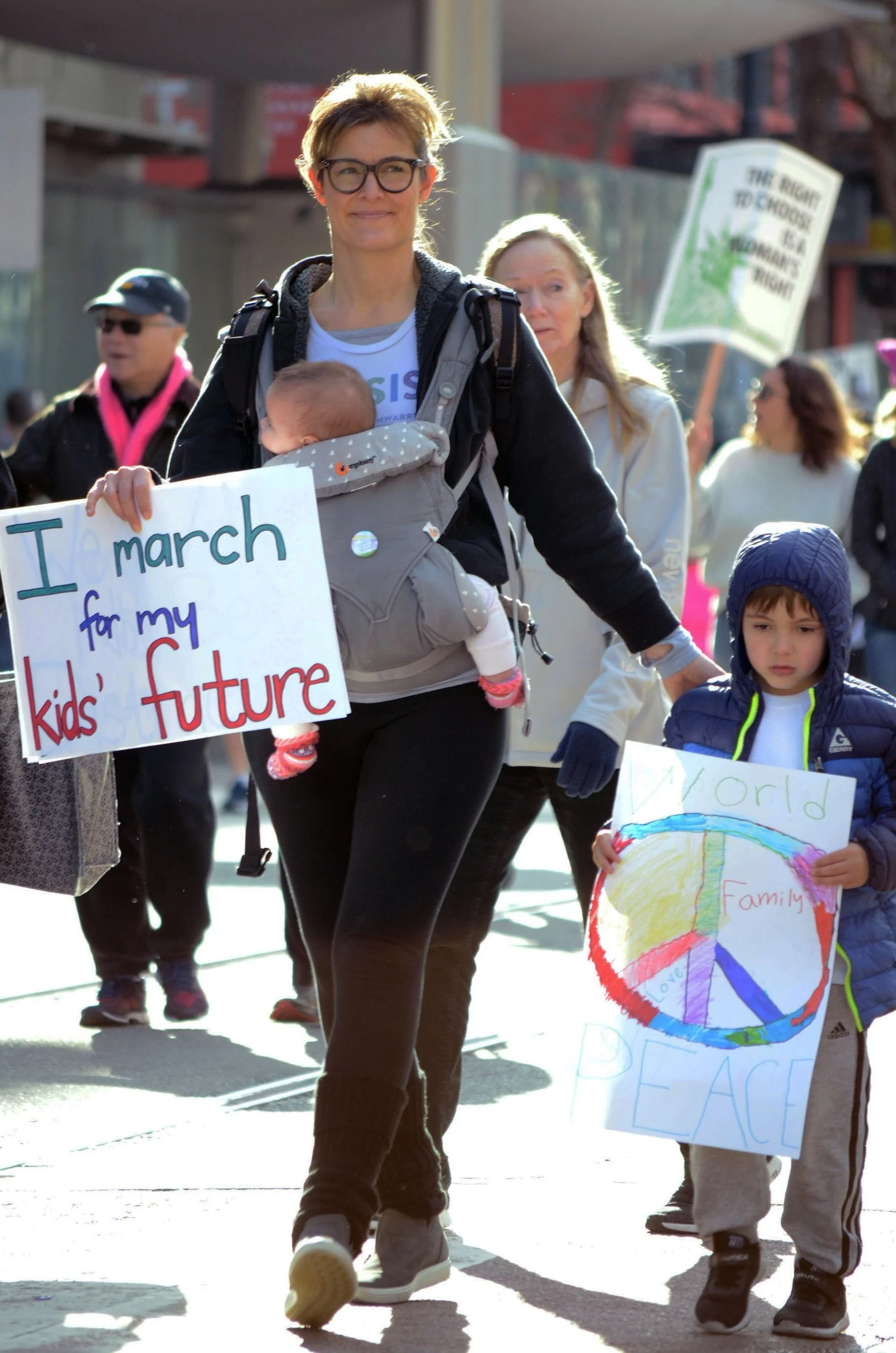 A mother marches with her two young children during the January 18, 2020 Women’s March in San Francisco. Roughly 12,000 demonstrators marched down Market Street to the Embarcadero, according to estimates provided by the march's press team. Photo by …