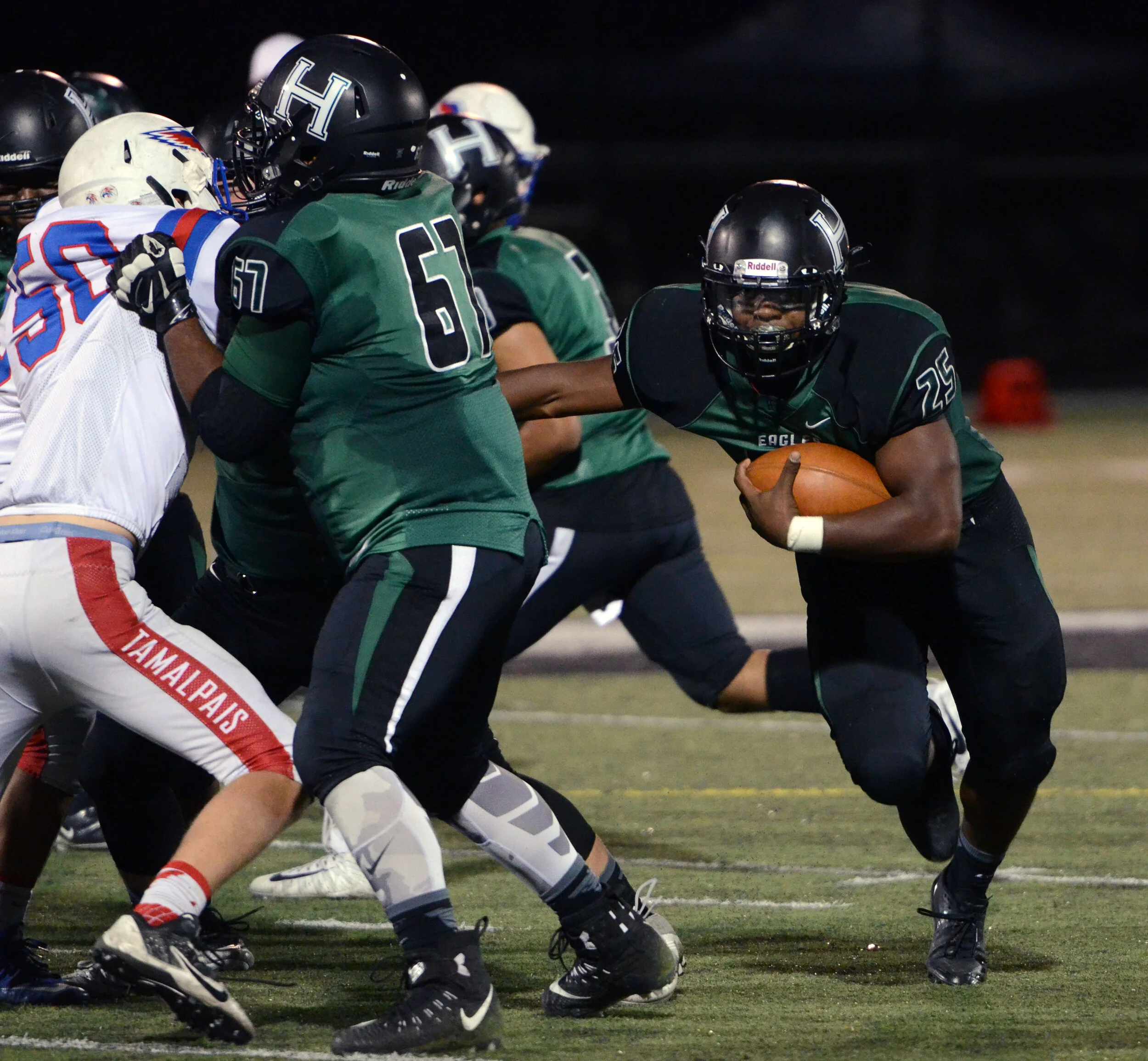 A Harker upper school football player runs with the ball behind friendly linemen in a game against Tamalpais High School on Oct. 6, 2017. The Harker team ended the season with 11 wins and one loss. Photo by Eric Fang