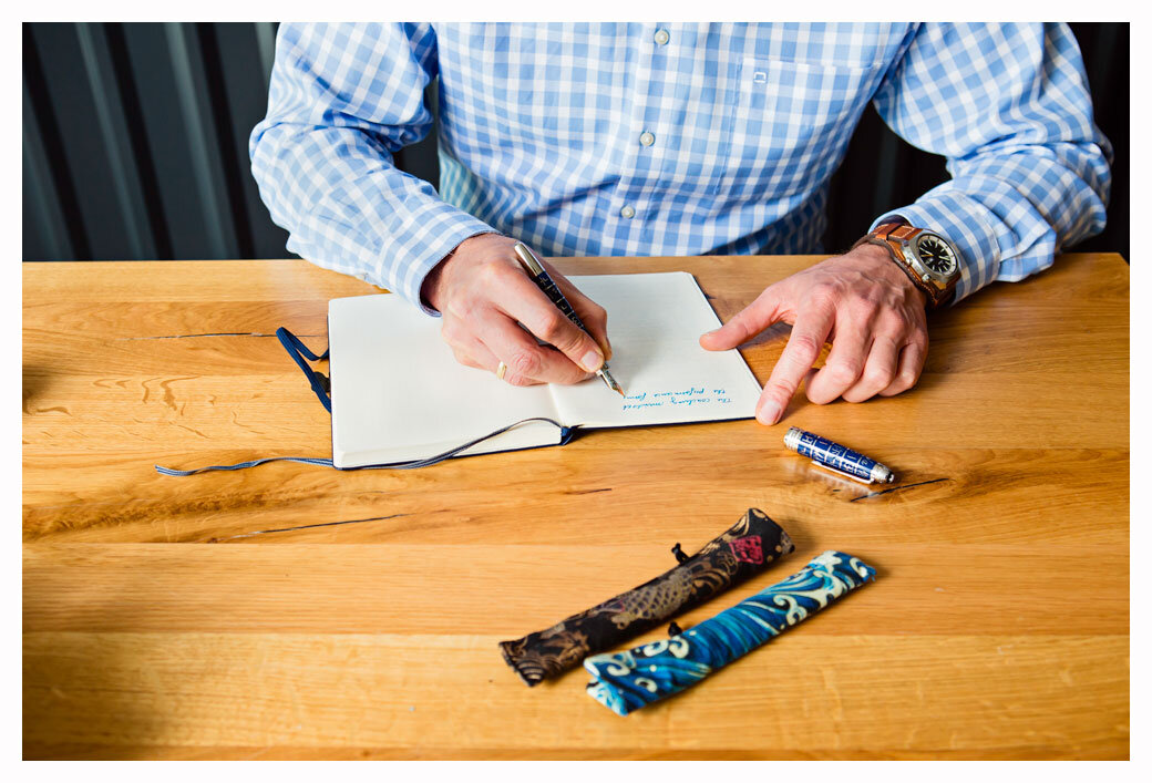 Jens Maxeiner Coach | journal writing with blue pen at desk