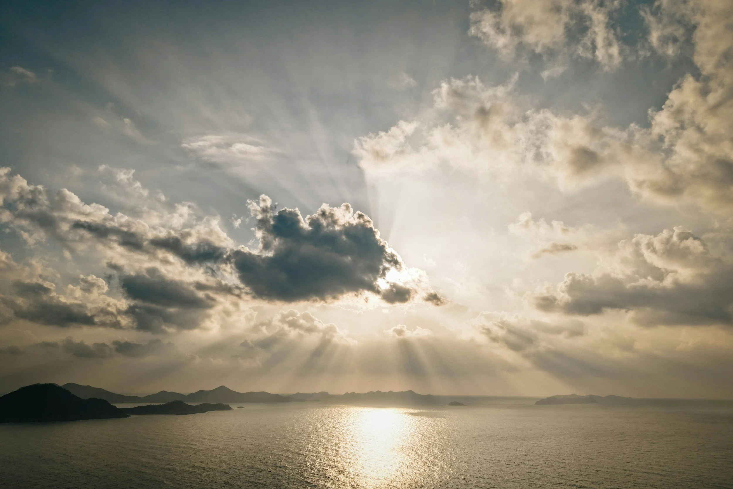 calm ocean, light through clouds