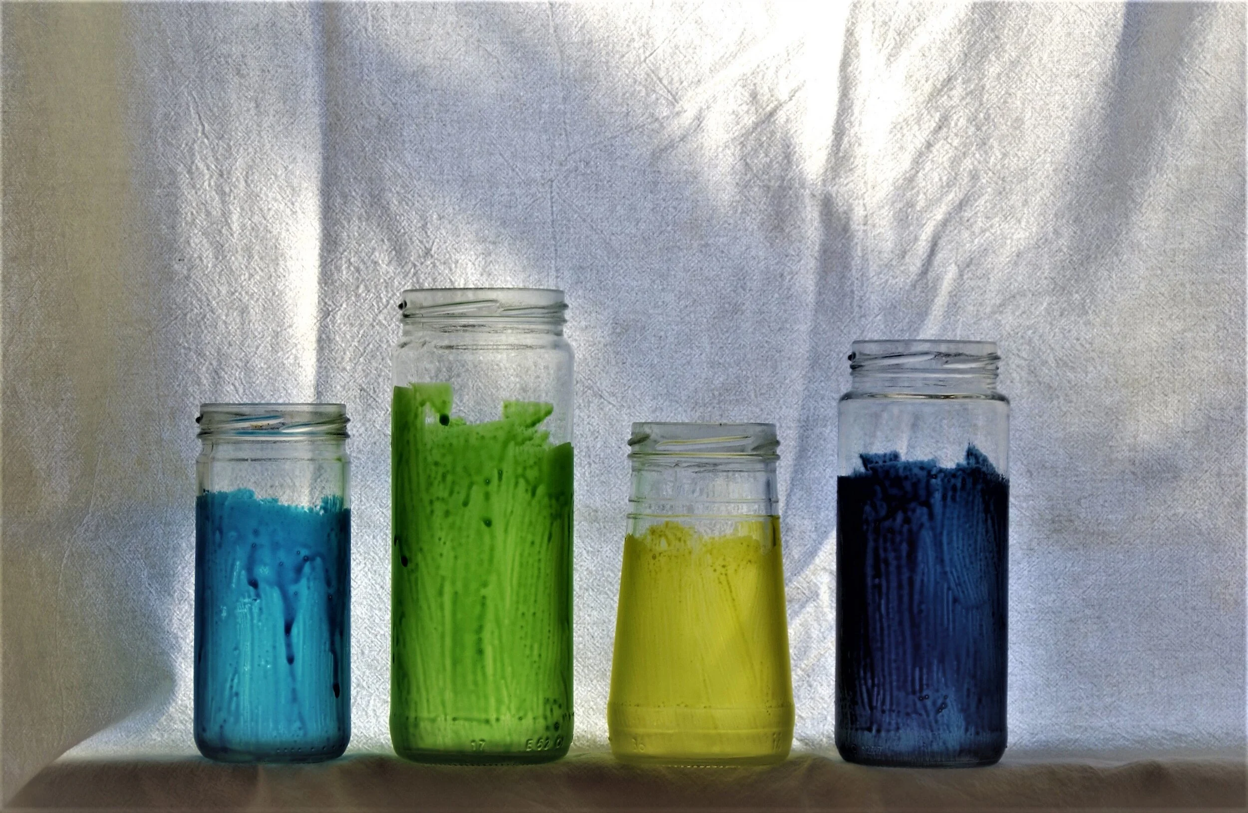  Four painted olive jars against a white background. 