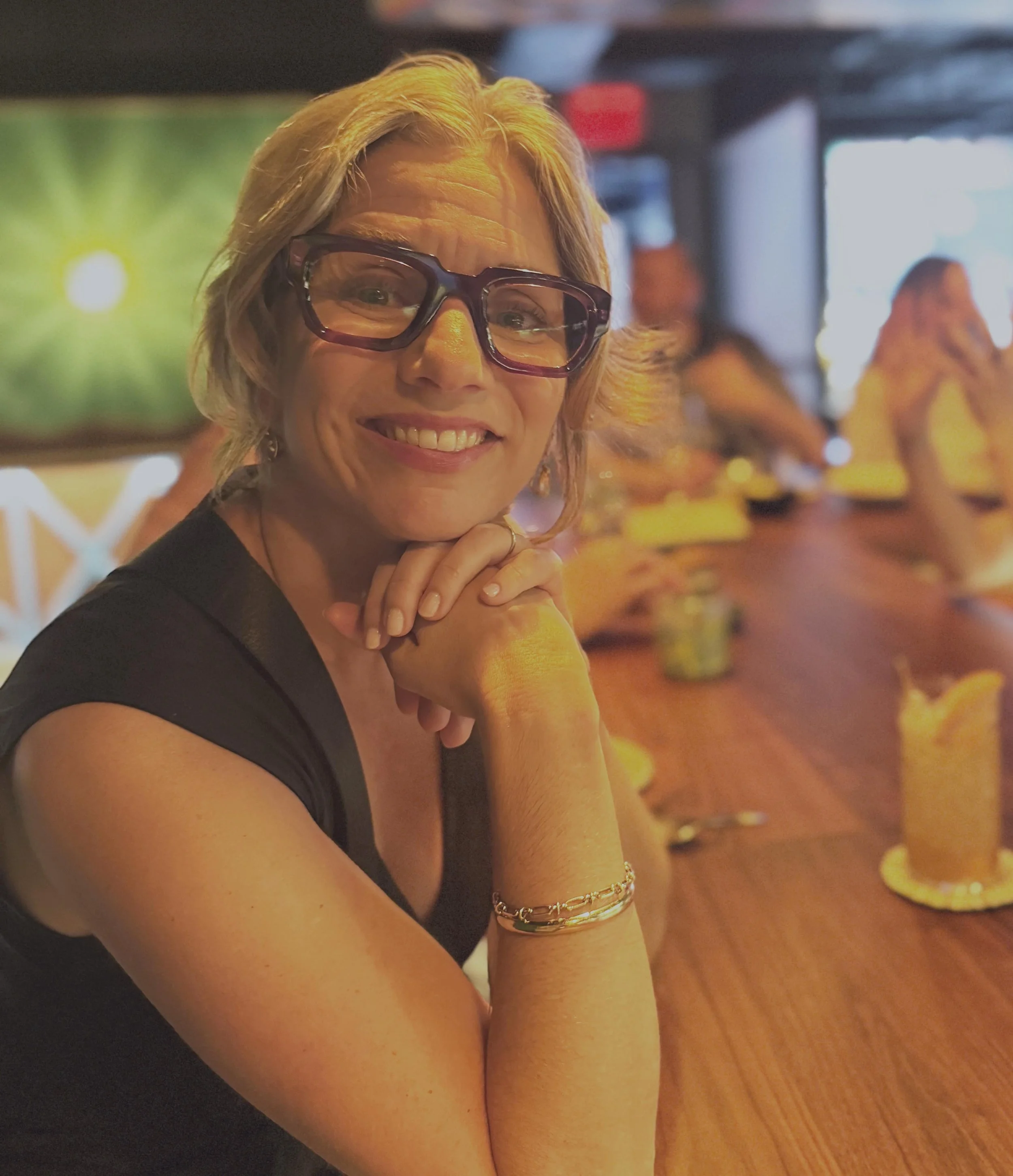 woman in glasses smiling at camer