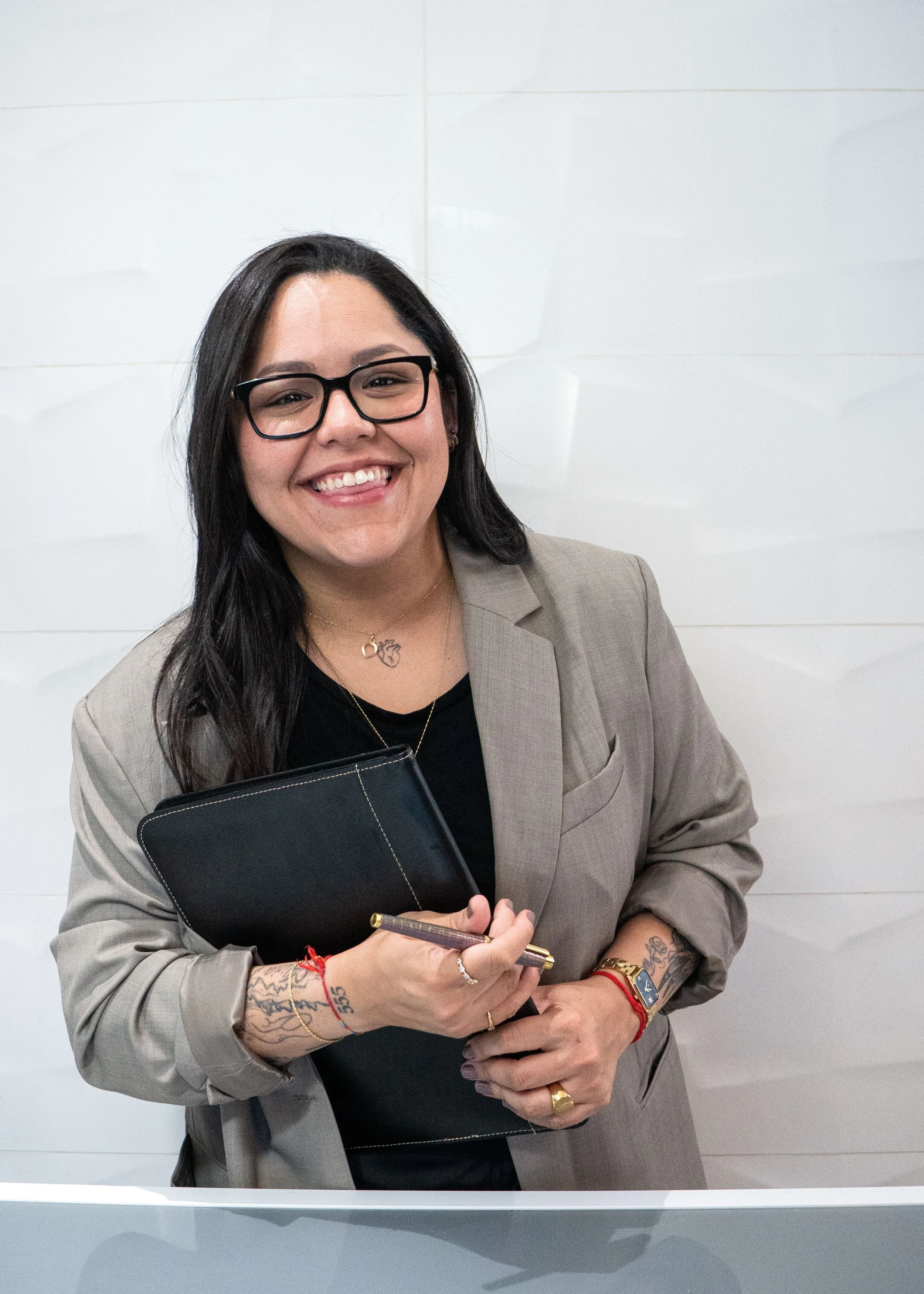smiling woman with glasses and grey jacket