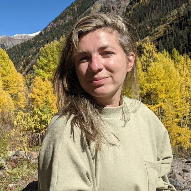 woman smiling at camera with mountains behind