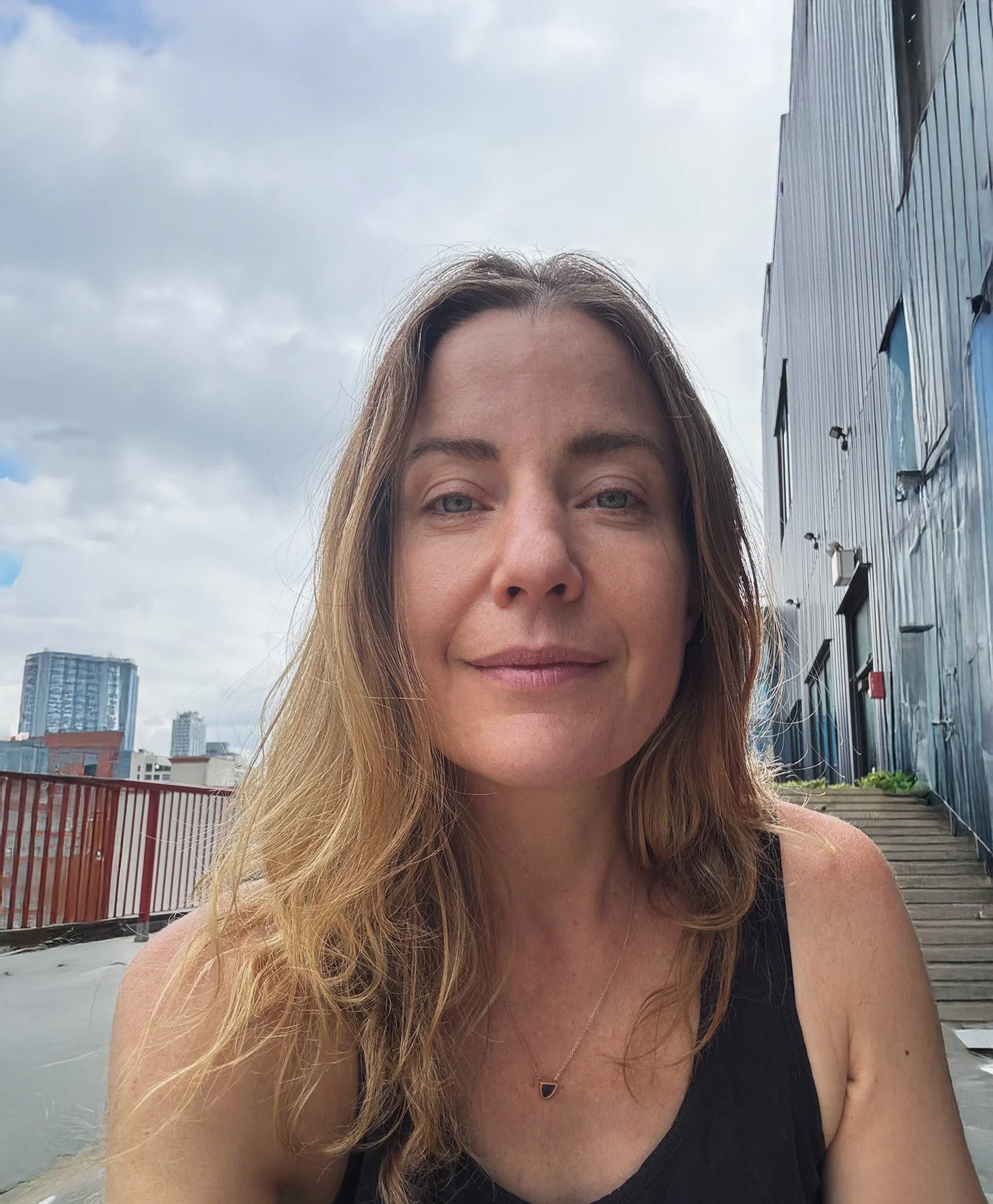 woman seated on urban roof deck considering NYC hospitality design