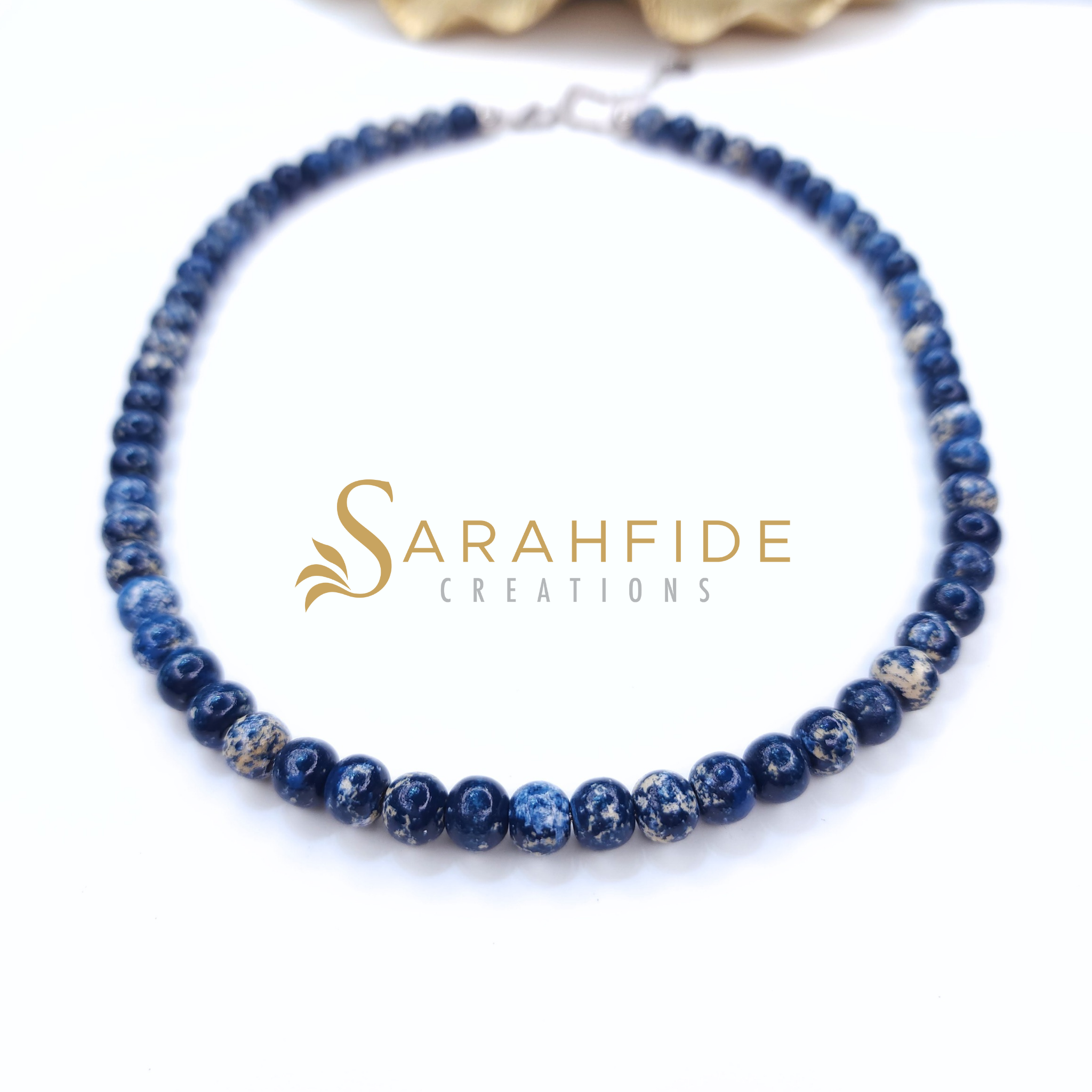 Denim blue beaded necklace laid flat