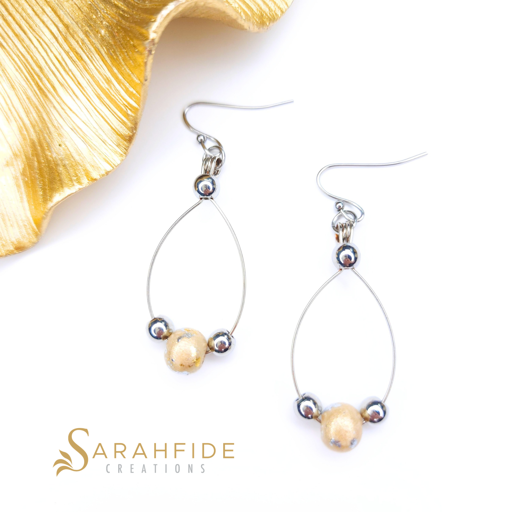 Gold sparkly drop earrings laid flat