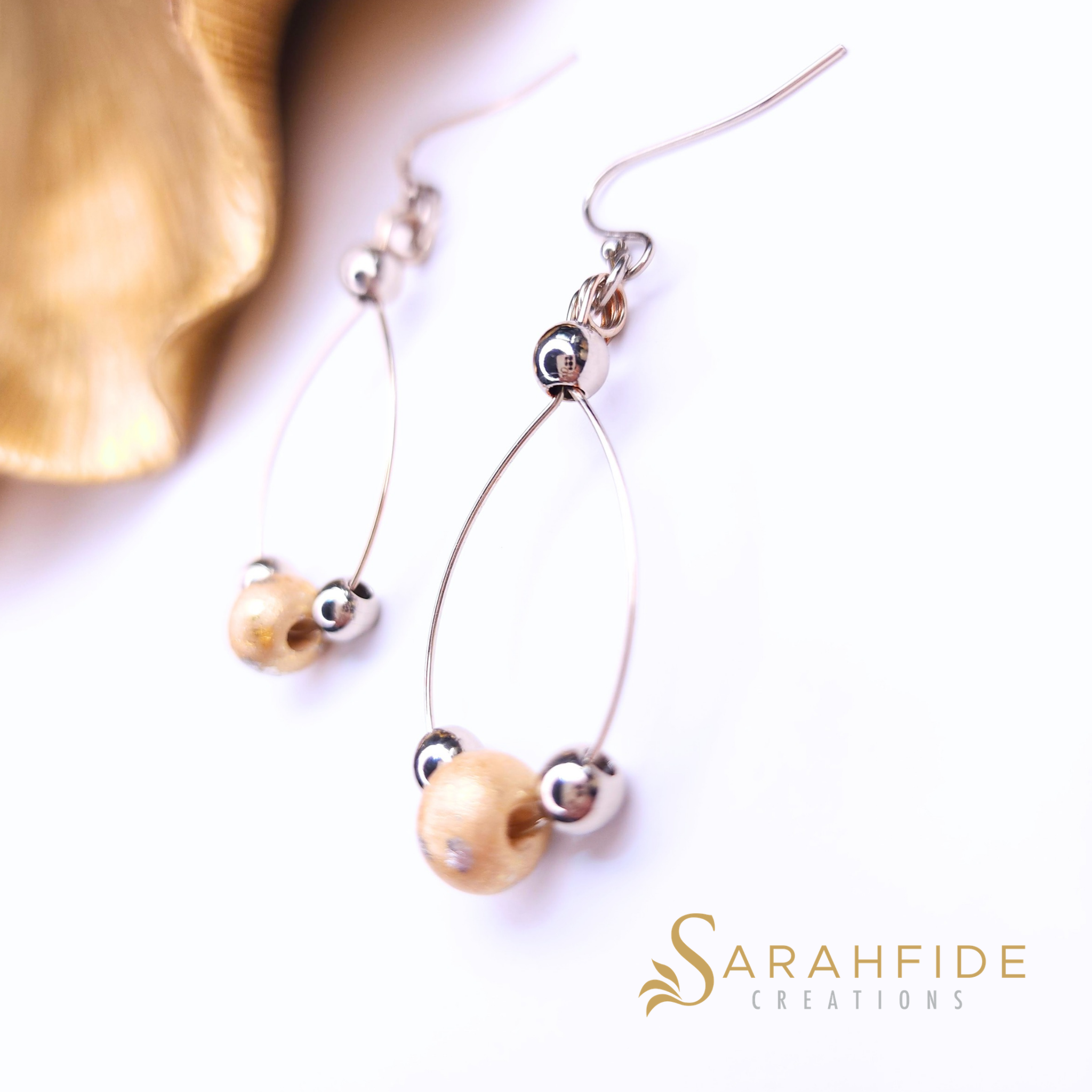Gold sparkly drop earrings laid flat