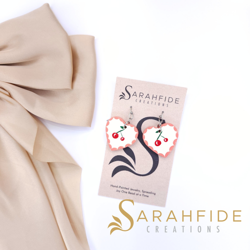 Sweet, playful, and full of charm! The Sweethearts & Cherries Collection features hand-painted hearts and cherries that bring all the joy to your everyday style. From chunky Elle Wood hearts to delicate Sabrina dangles and adorable cherry designs, ea
