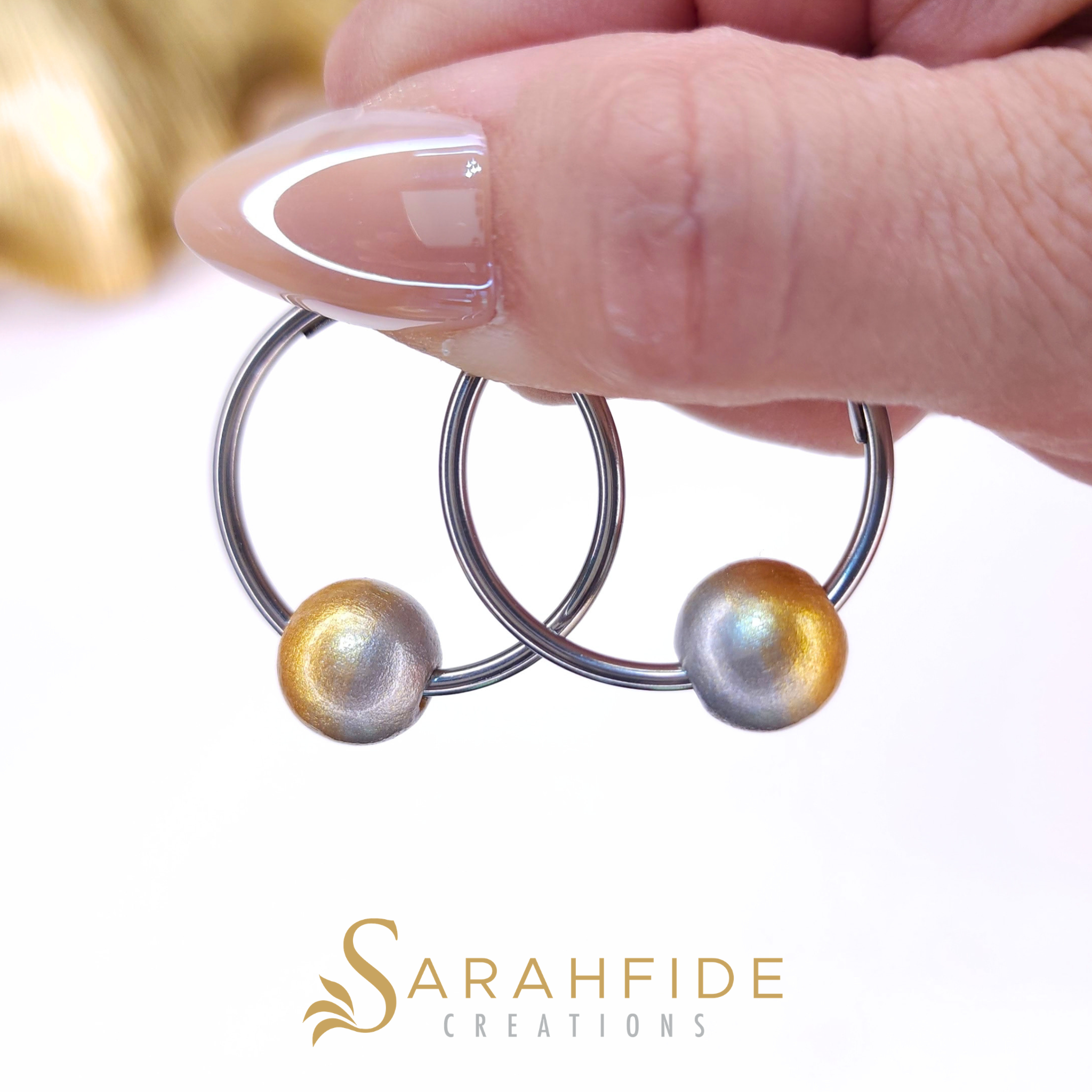 Platinum Small Hoop Earrings with silver hoops, held in hand