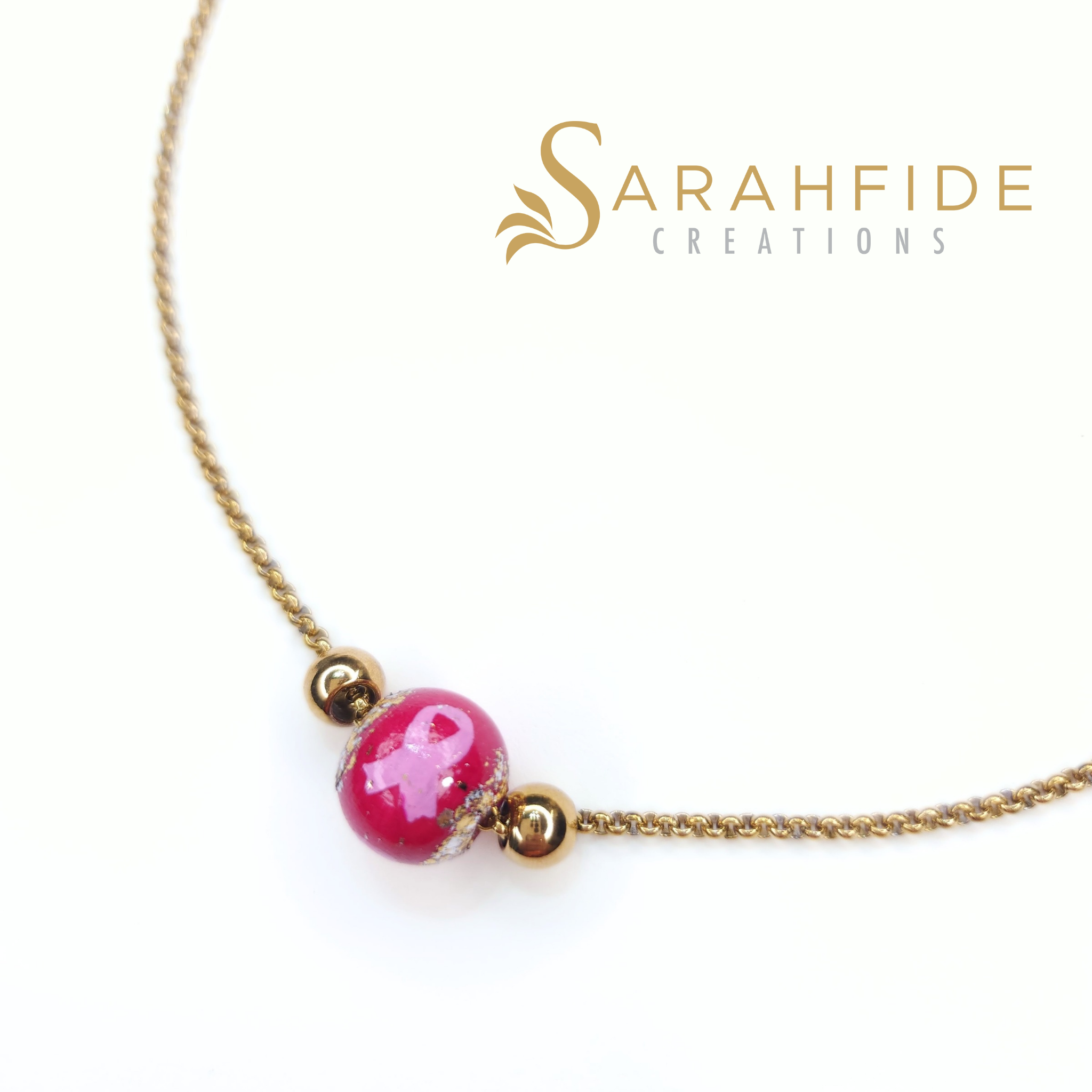 Close up of the hand-painted pink ribbon on the Breast Cancer Awareness necklace bead