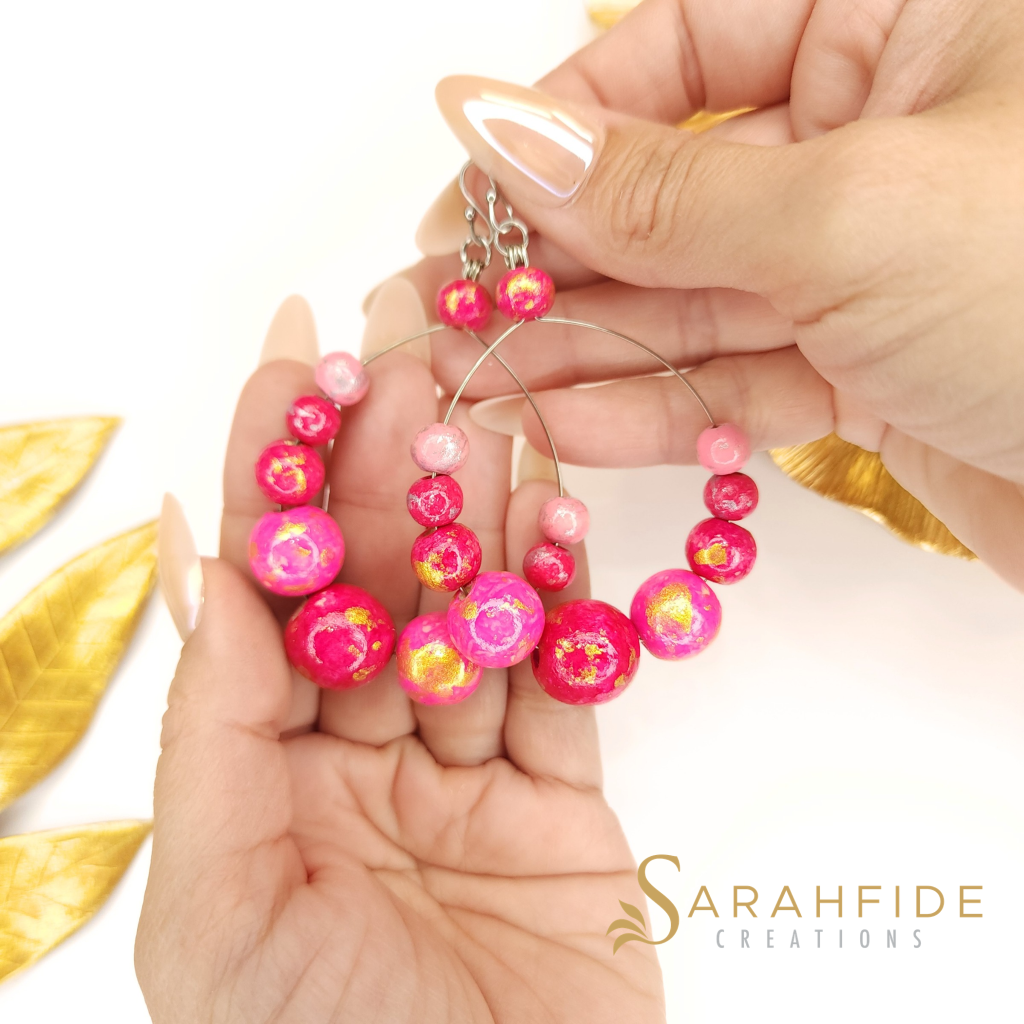 Pink Color Pop Large Round Drop Earrings held in a hand, shades of pink wood beads
