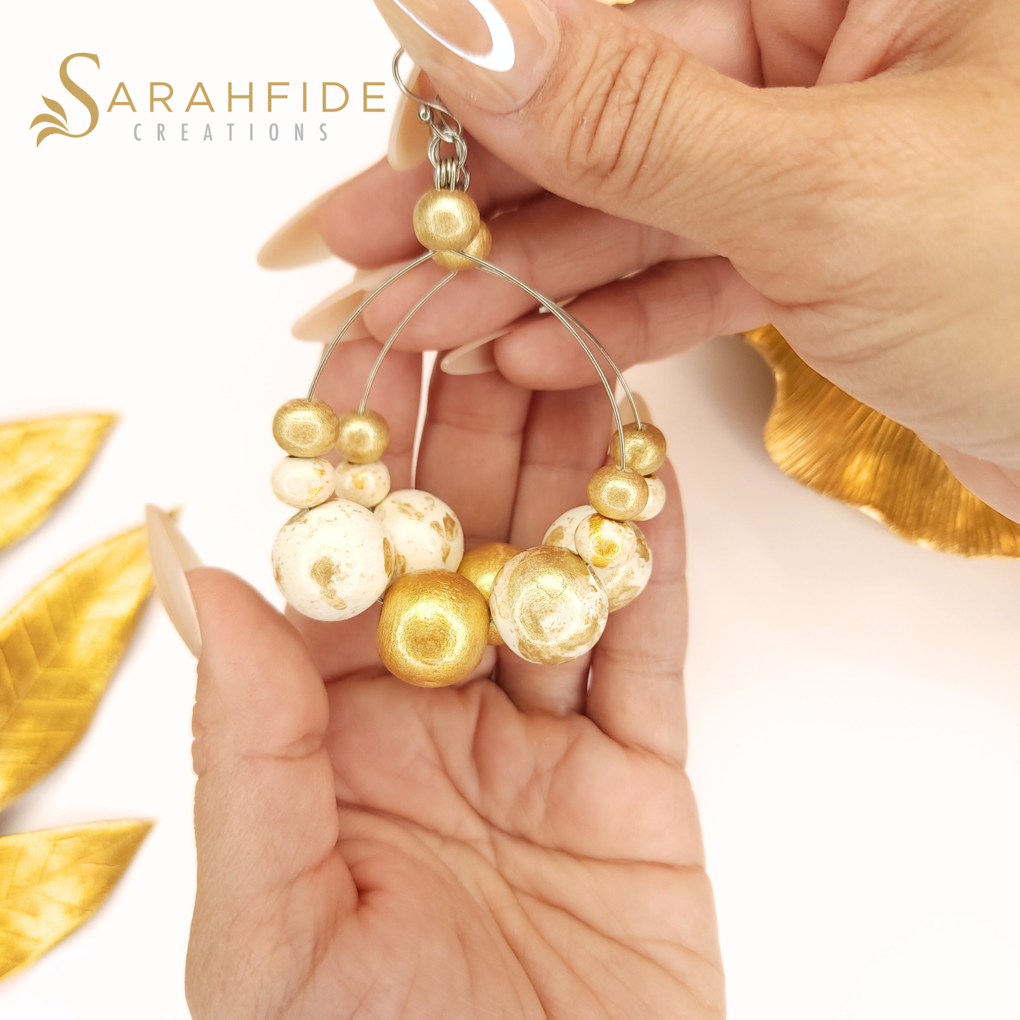 Gold Lux Large Round Drop Earrings held in a hand
