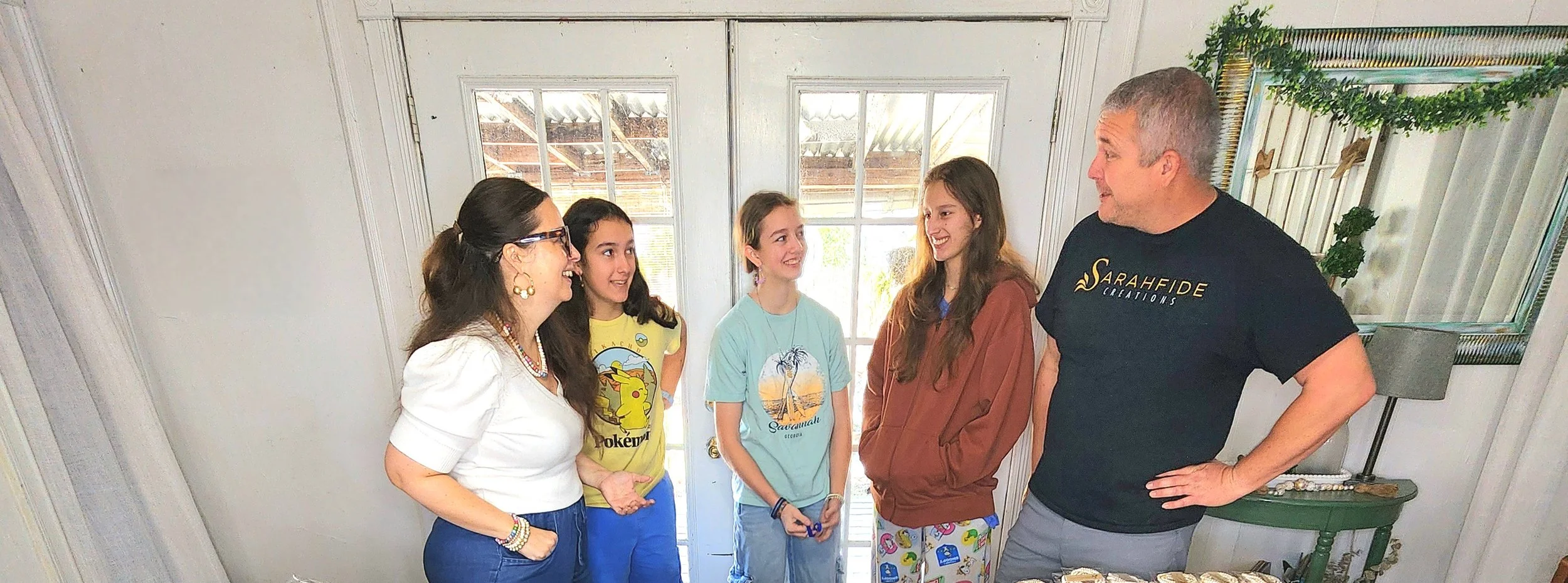 Sarahfide family working together at their stations to fulfill wholesale jewelry order in the studio