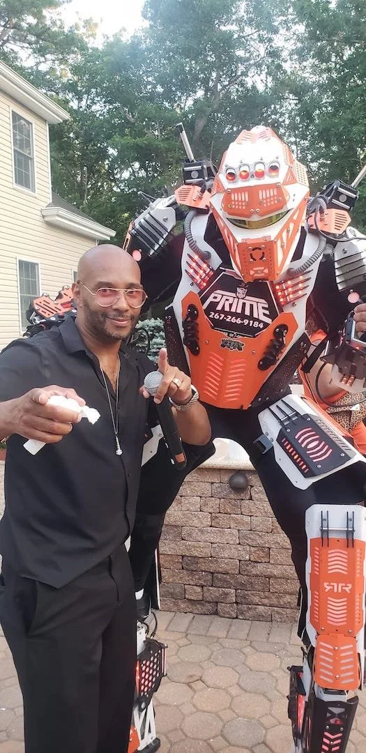 Victor James standing beside the larger-than-life Turn Up Robot