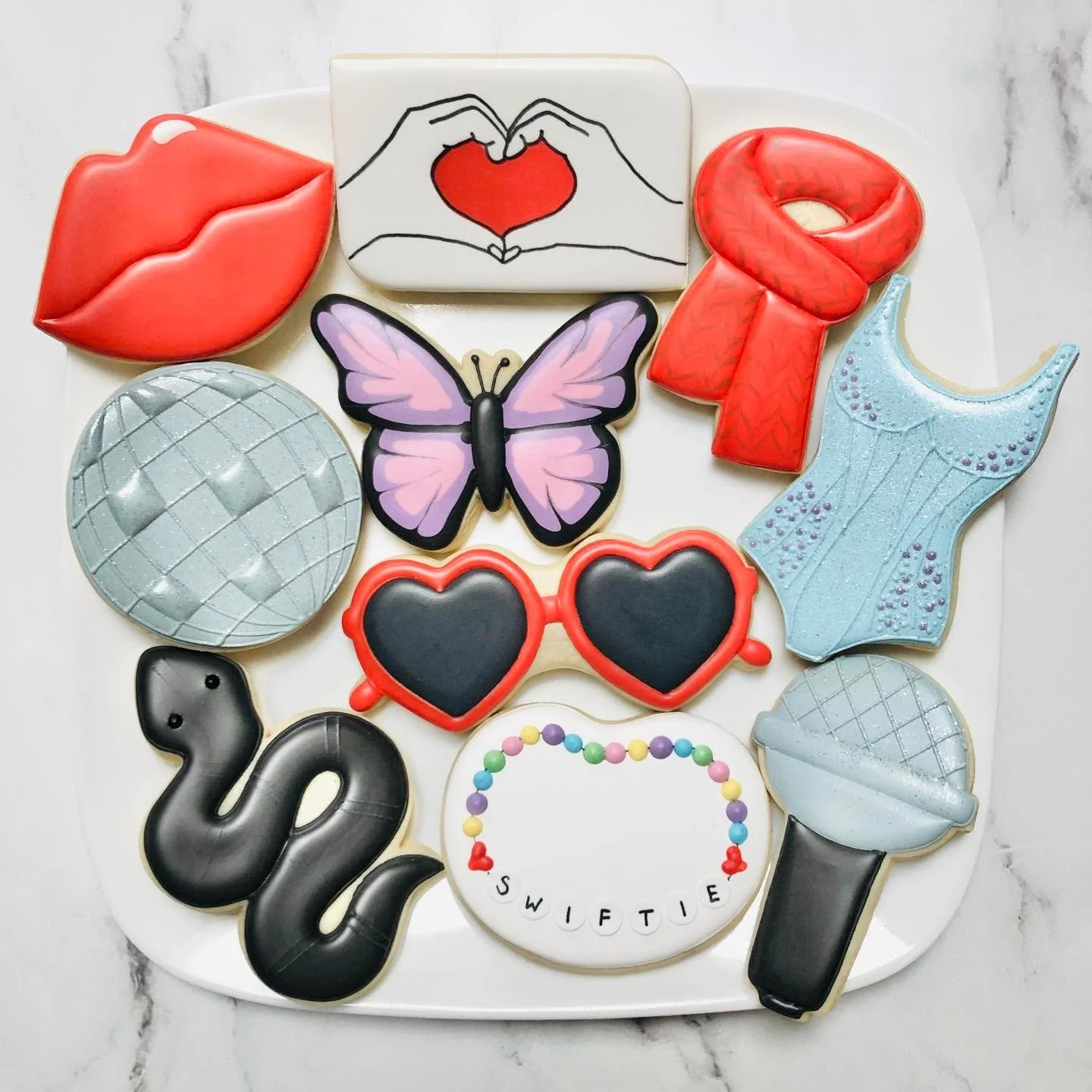 Cookies for a Taylor Swift-themed birthday party! 💋🎤🧣🦋🐍🕶️🪩
.
.
.
. 
#taylorswift #swiftie #happybirthday #happybirthdaycookies #birthdaycookies #birthdaytreats #birthdaypartyfavors #partyfavors #momsofinstagram #cookiefavors #royalicing #royal
