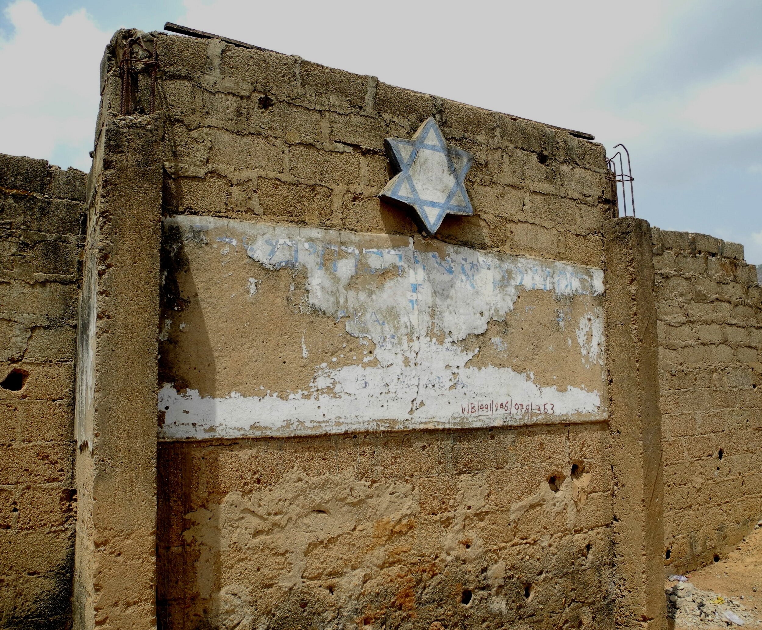 Wall with faded Hebrew writing near Tikvat Israel Synagogue in Abuja, Nigeria. Photo — Shai Afsai
