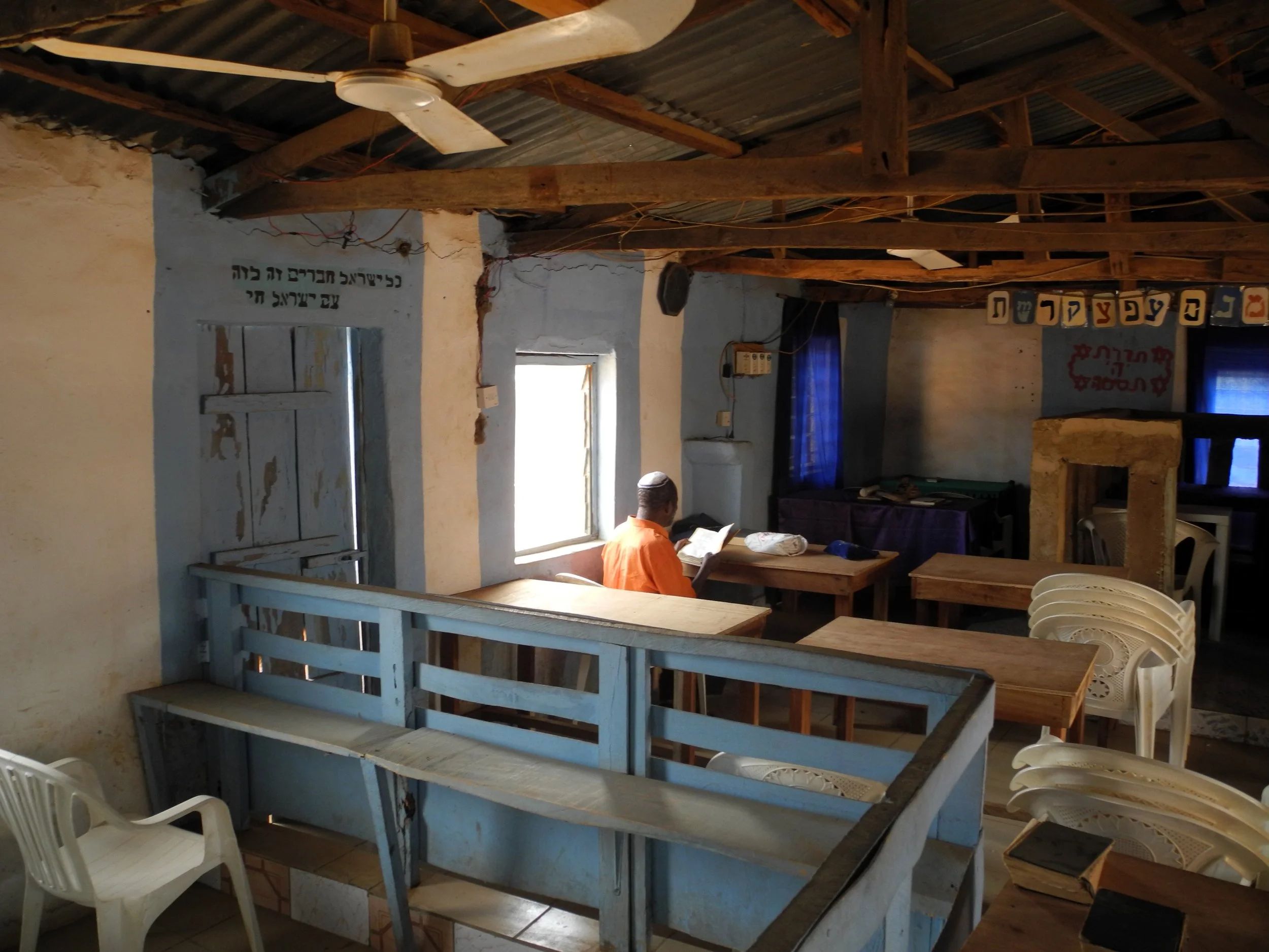 Emanuel ben David at prayer by an open window at Tikvat Israel Synagogue in Abuja, Nigeria. Photo — Shai Afsai