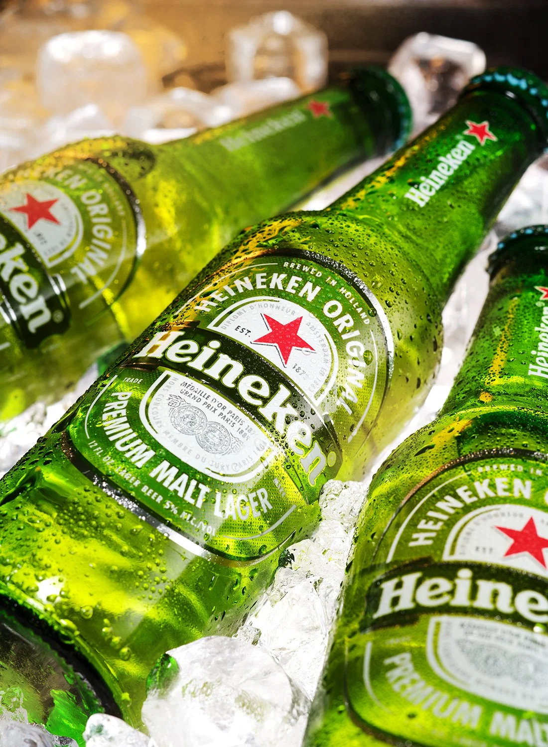 Product photography of Heineken bottles resting on ice, highlighting cold condensation and label detail, photographed by Takamasa Ota in New York.