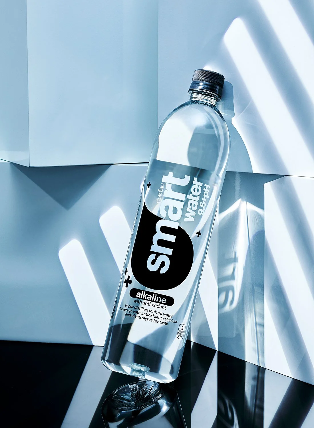 Smartwater Alkaline bottle styled with geometric shadows and modern studio lighting, premium water product photography by Takamasa Ota in NYC
