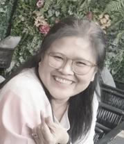 Smiling woman with glasses in front of a floral background