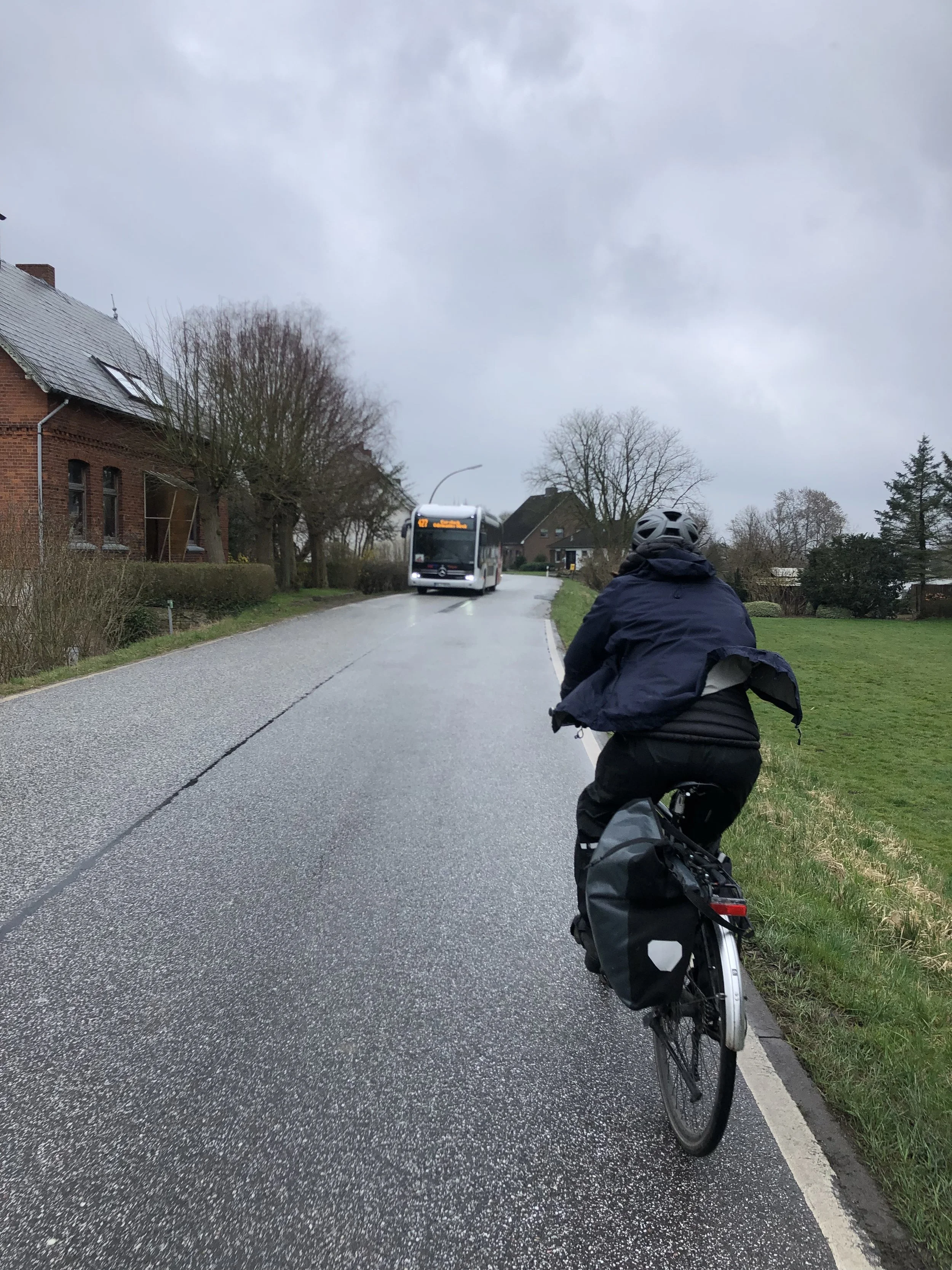 Fotoi aus den Vier- und Marschlanden. Radfahrerin von hinten auf einer Straße. Ein Bus kommt entgegen. Projekt Mobilitätskonzept Vier- und Marschlande von CITIES FOR FUTURE.