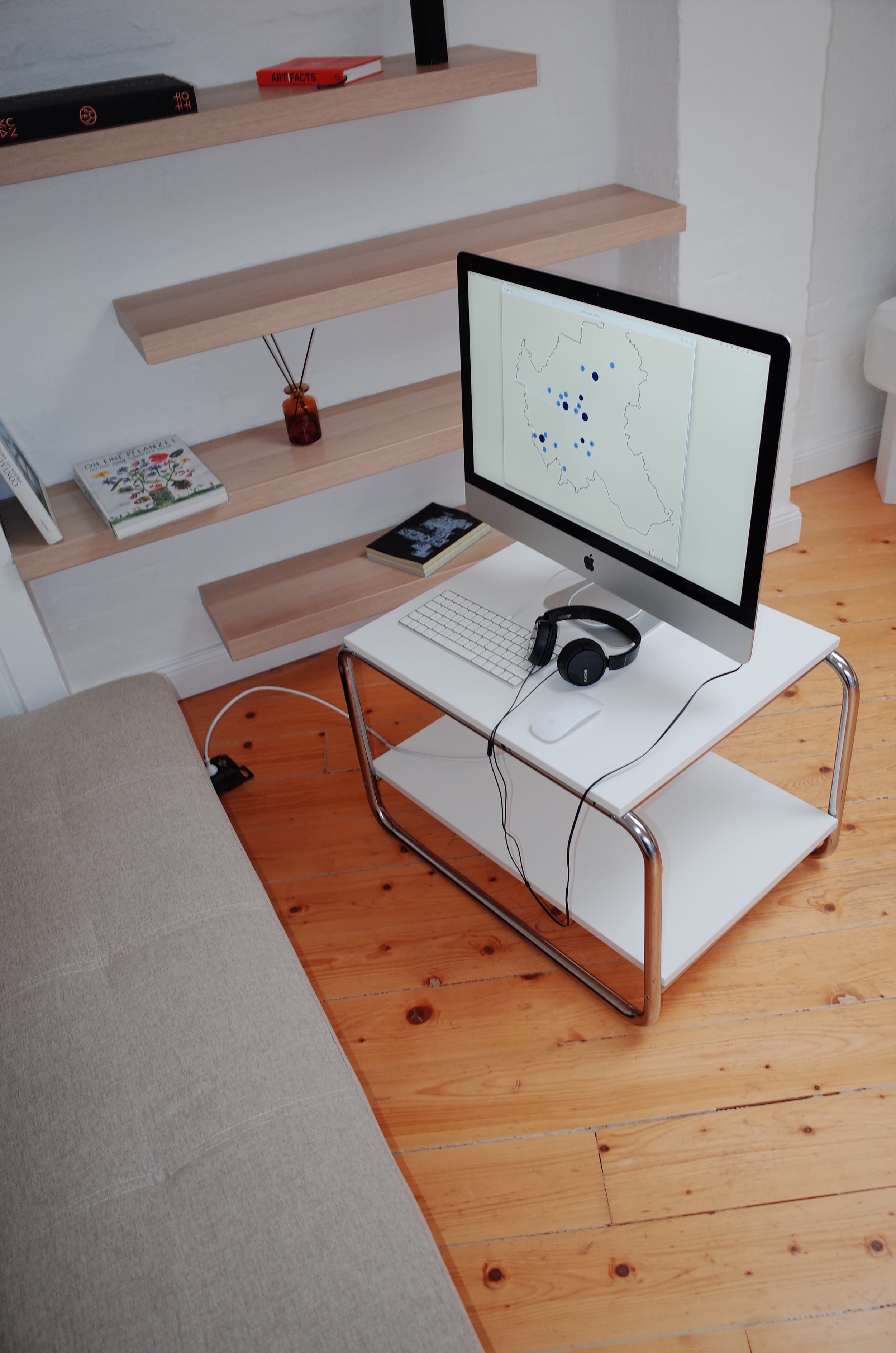 Schreibtisch mit einem Computer, Kopfhörern, Büchern und Regalen im Hintergrund.
Sustainability Week 2026. Ausstellung im Loft141.