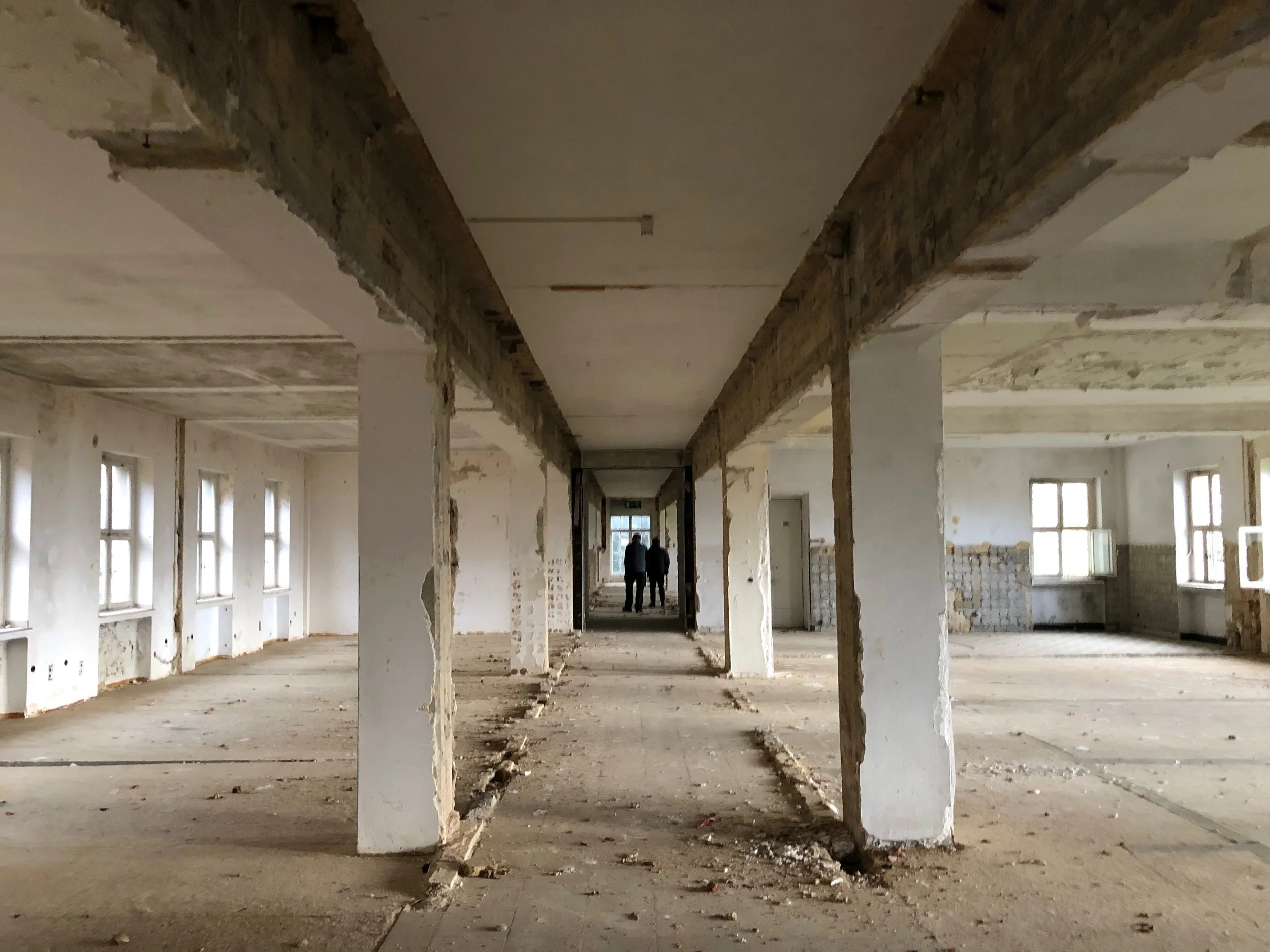 Innenaufnahme vom Vialife Campus Bardenberg. Leerer und herunter gekommener Raum mit mehreren weißen Pfosten.