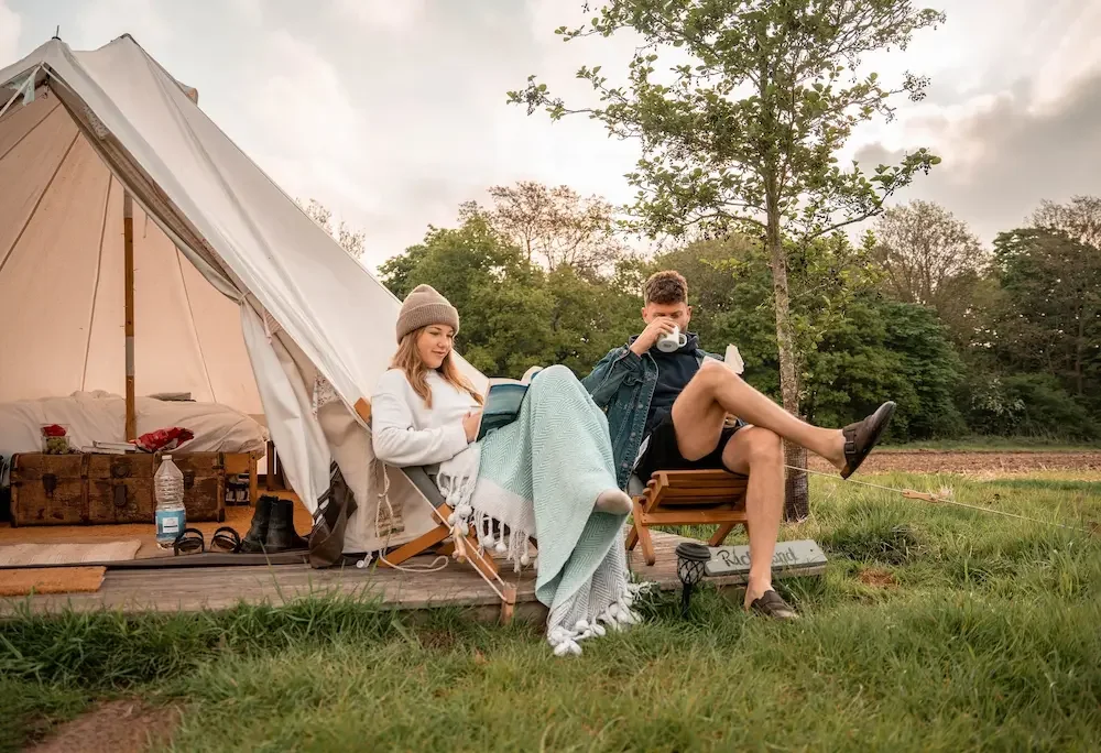 Glampers relaxing outside bell tent at Home Farm near London