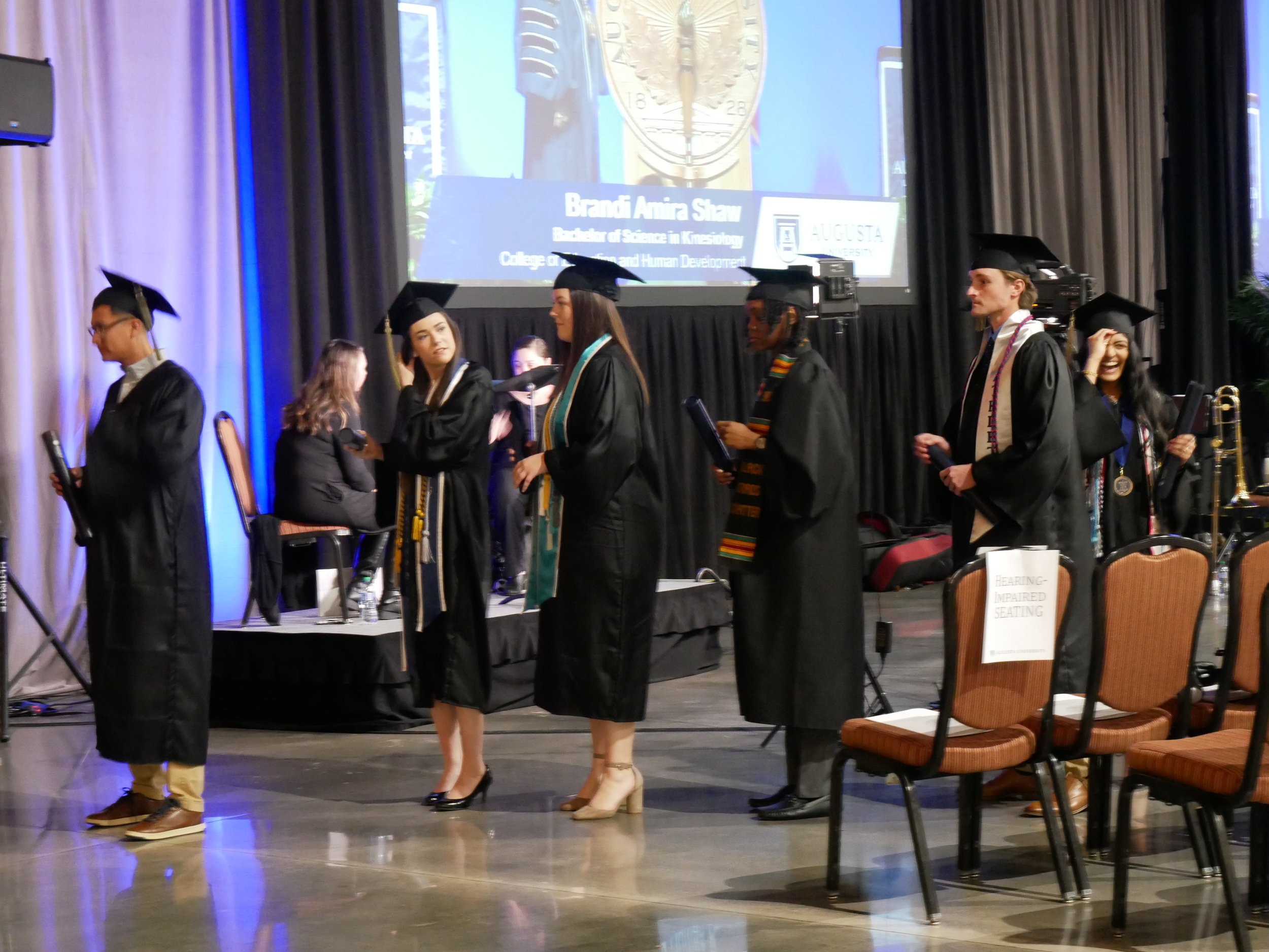  Graduates wait in line to have their photos taken at commencement.  (photo by Brionna Law)  