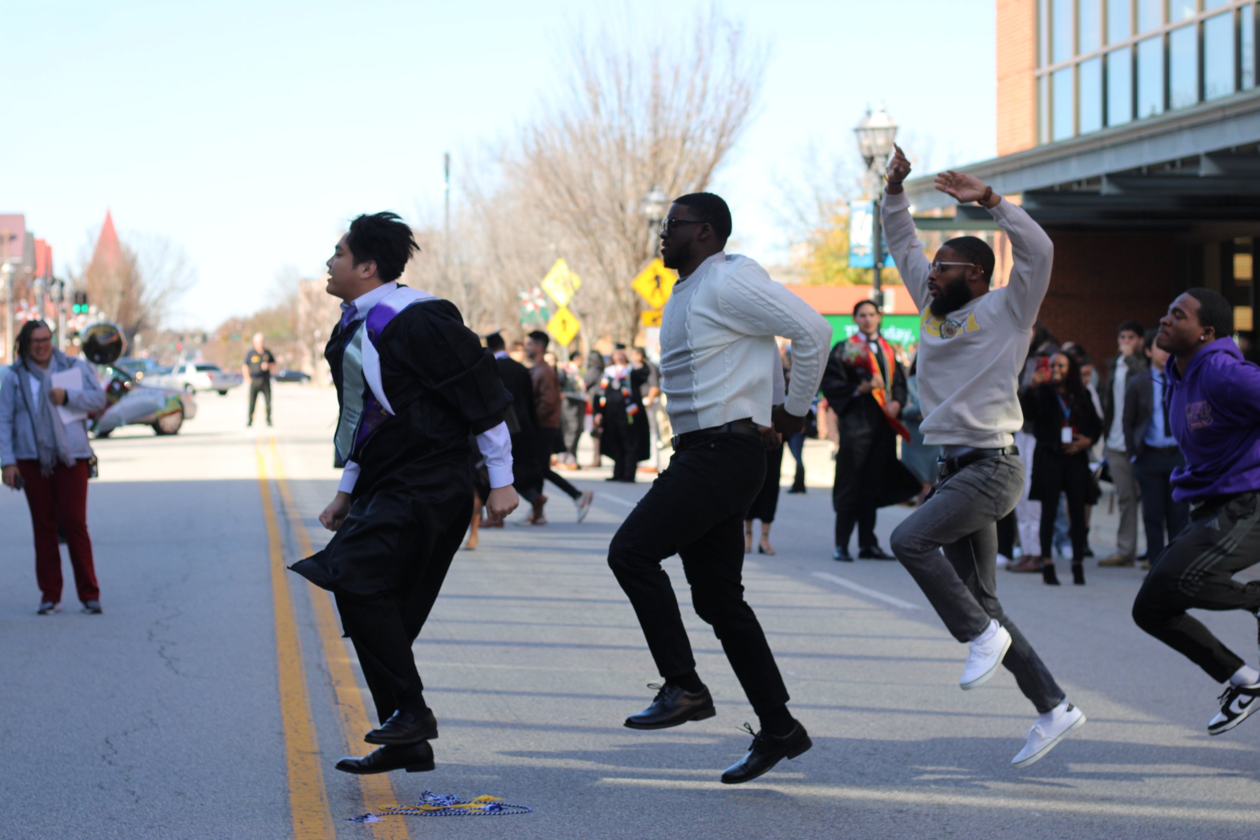  Fraternity members celebrate in the street after graduation.  (photo by Rakiyah Lenon)  