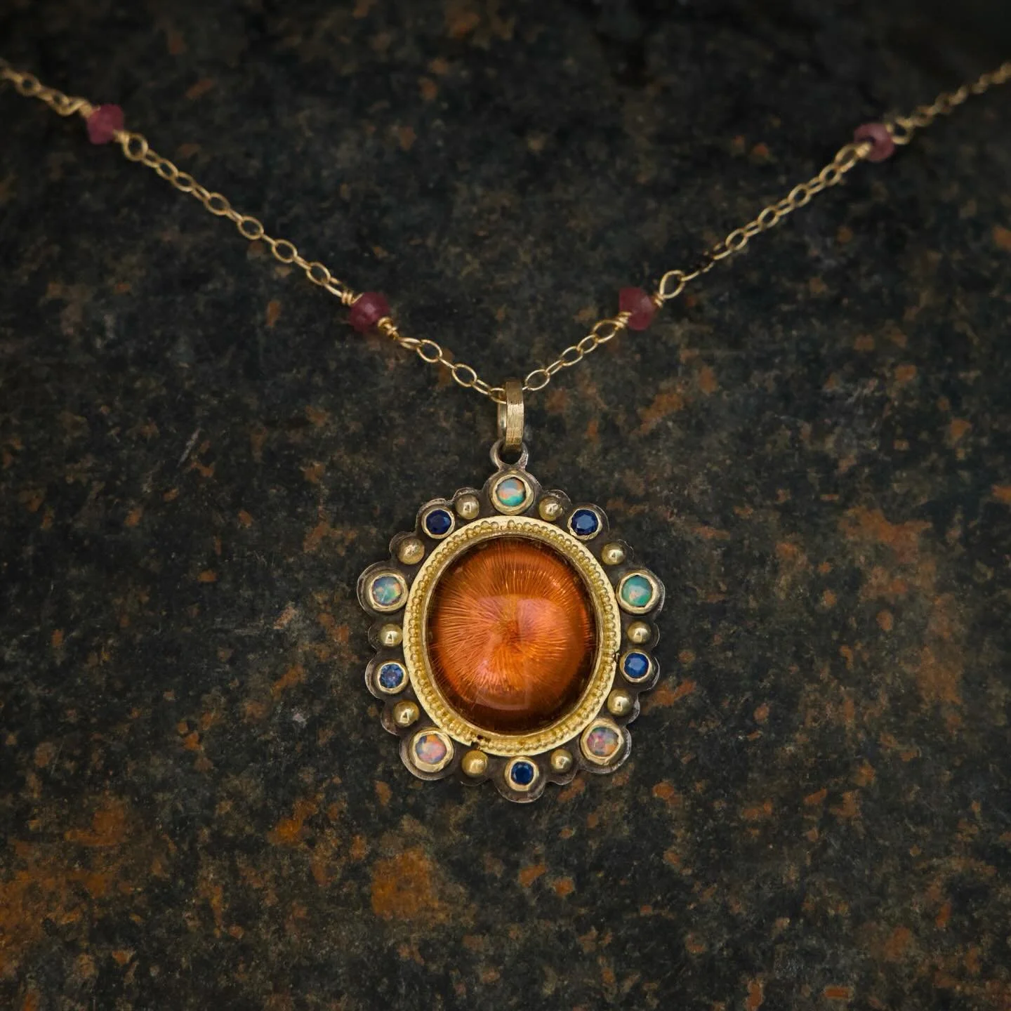 This pendant was made for a dear friend and each stone was chosen for its healing attributes and symbolism.
A beautiful pink tourmaline sits at the center radiating love, gentle strength, and inner resilience. Five opals and five blue sapphires add i