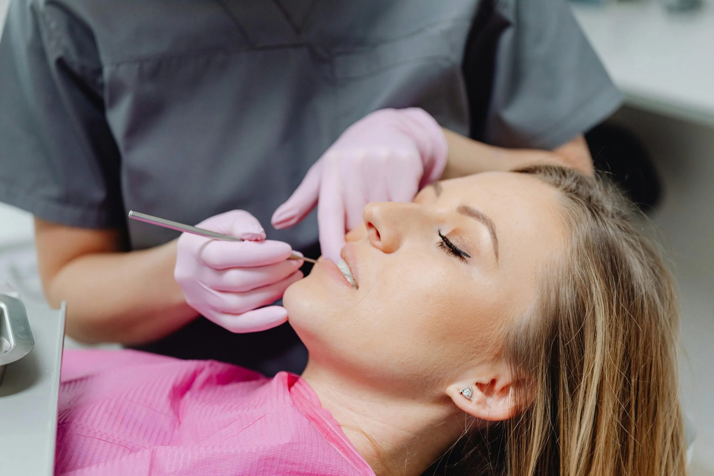 Female cosmetic dentist conducting a comprehensive dental exam in a high-end practice