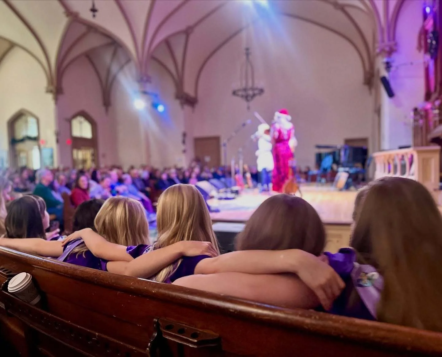 A group of dancers from the Oregon Irish Dance Academy sit together and watch The Gothard Sisters perform their Christmas concert onstage at the Old Church Concert Hall in December, 2025.