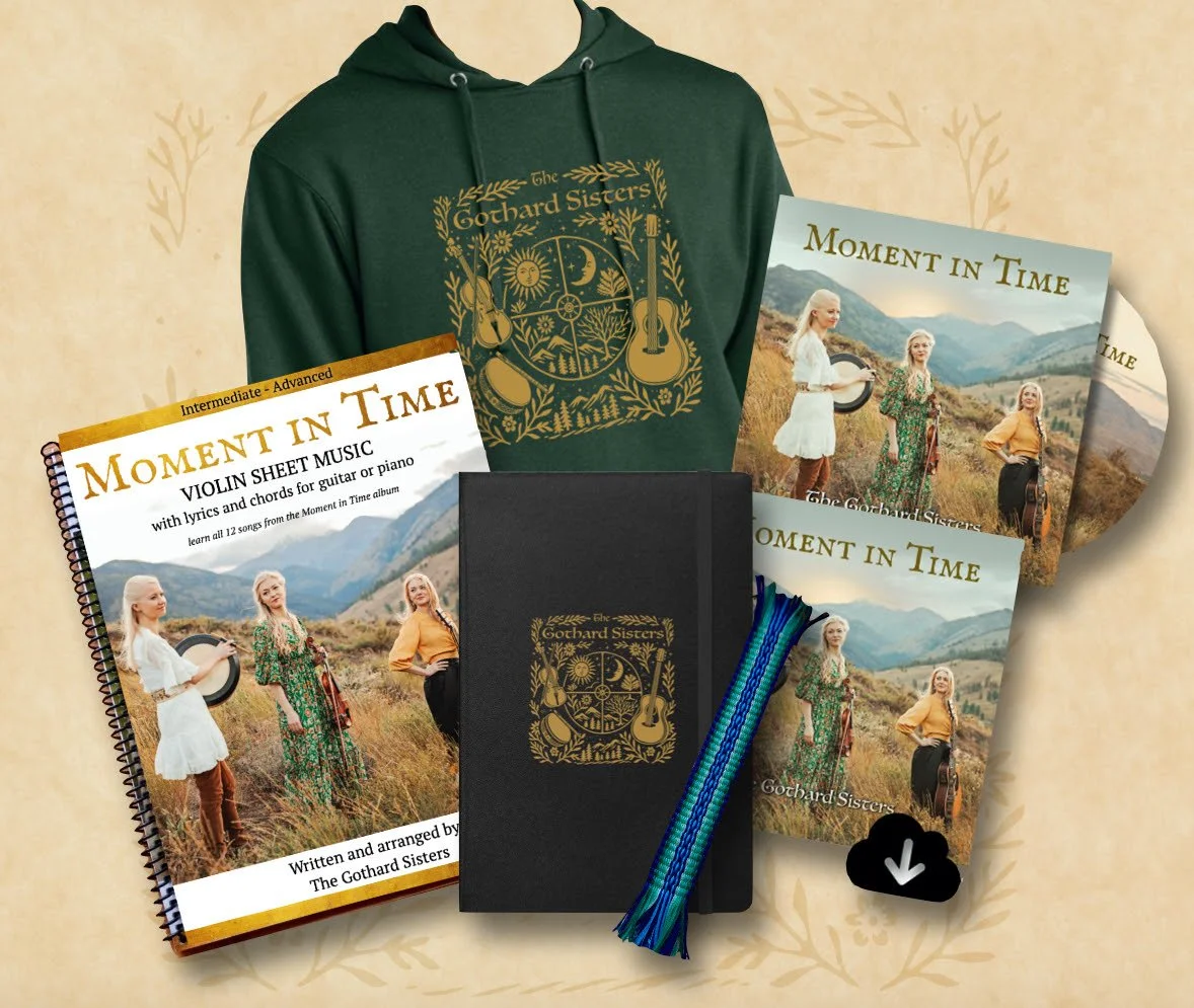 "Moment in Time" album release bundle by The Gothard Sisters: a soft "Moment in Time" hoodie in forest green, the "Moment in Time" album on both CD and as a digital album, a handwoven bookmark, lined journal, and violin sheet music book.