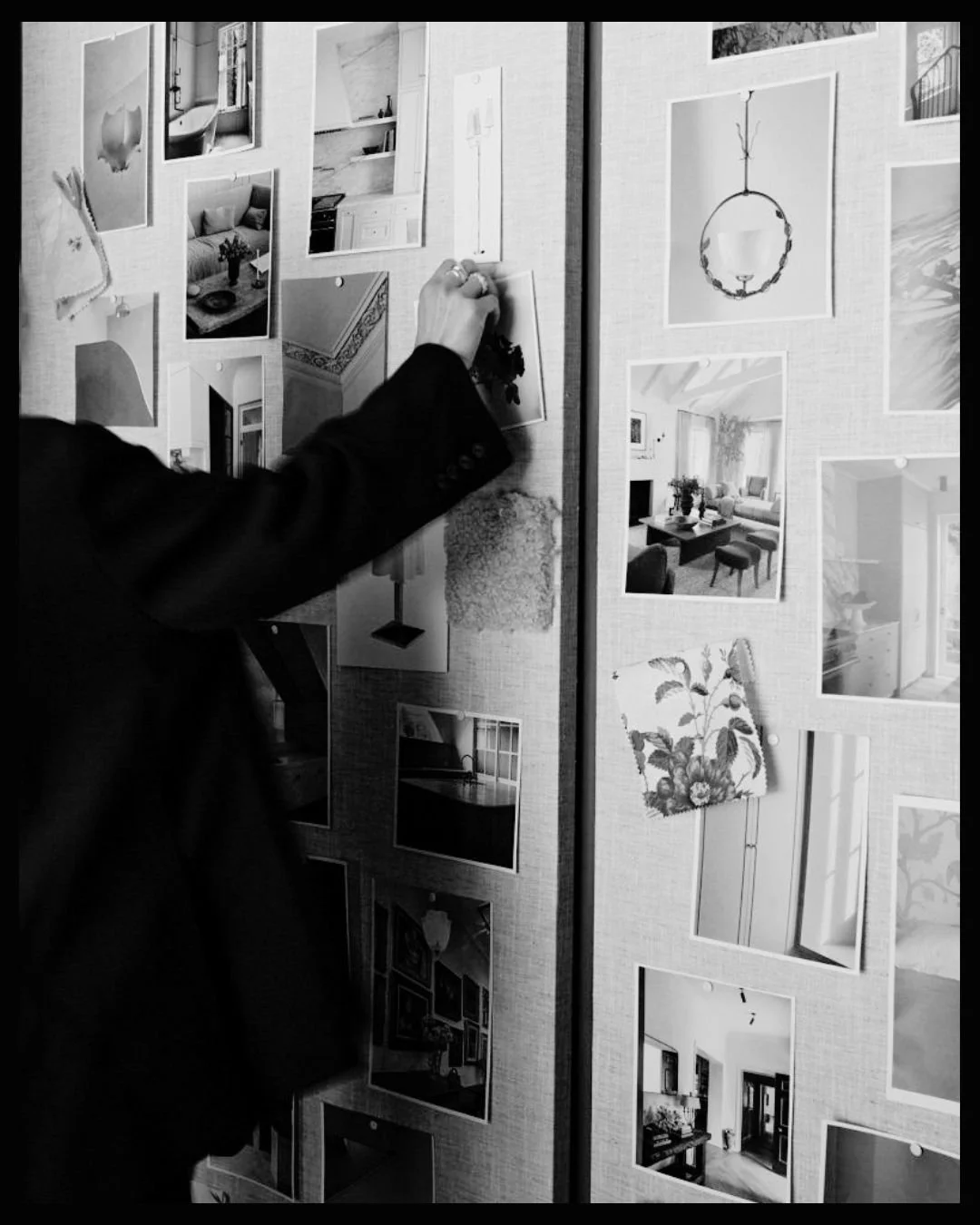 Xitlalt Herrera attaching black-and-white photographs to a display board featuring interior design images.