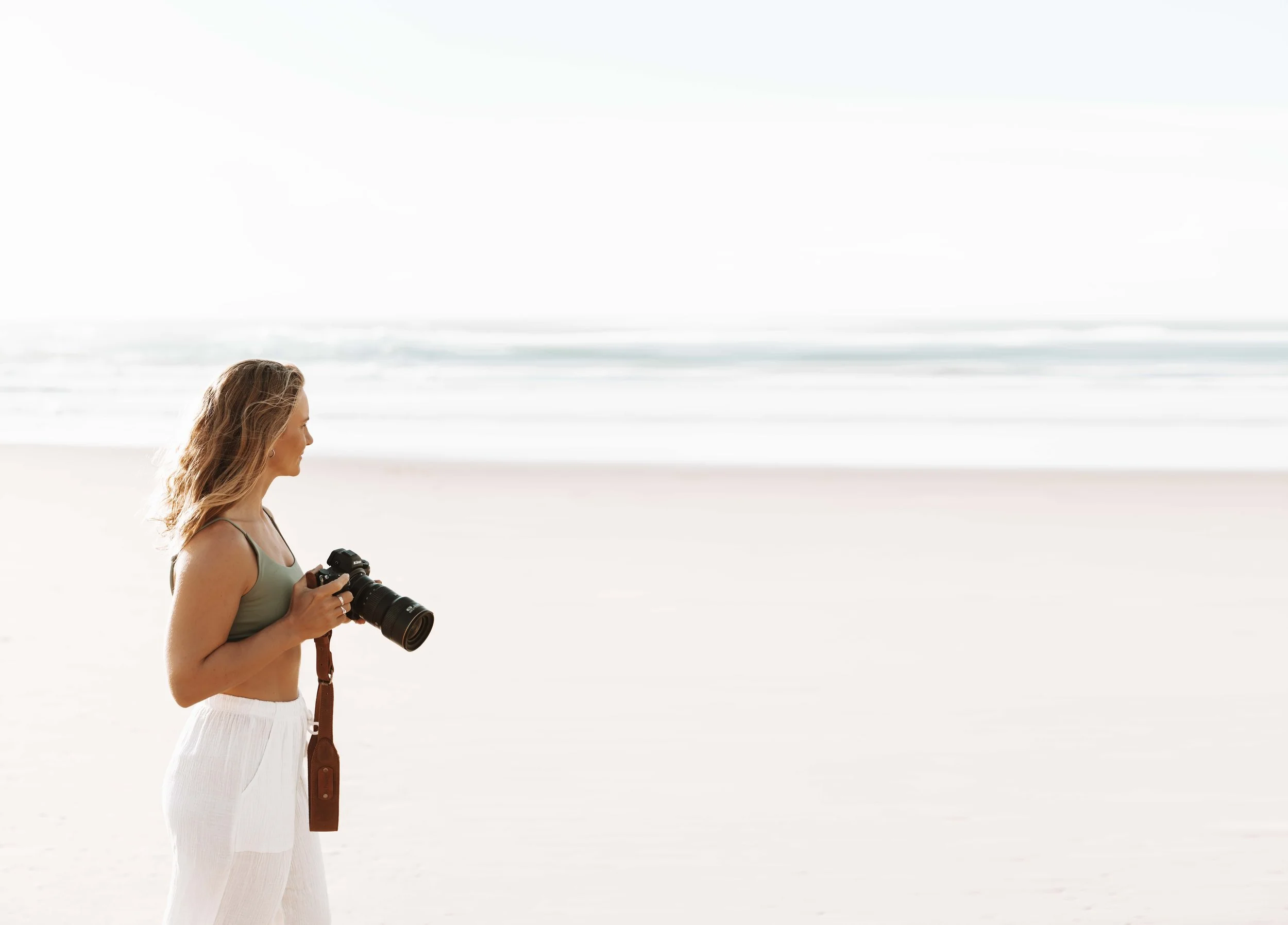 Female photographer on the beach with her camera