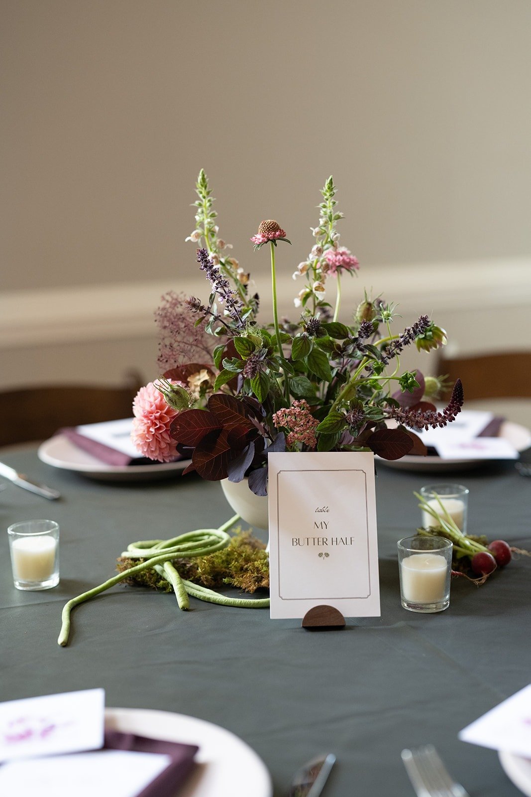 Reception tables set with flowers and assigned seating inside the Grand Ballroom at The Matthews House in Cary.