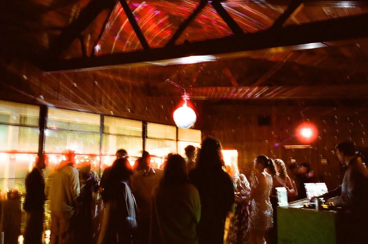 Disco ball above crowd as they dance at a micro wedding in North Carolina