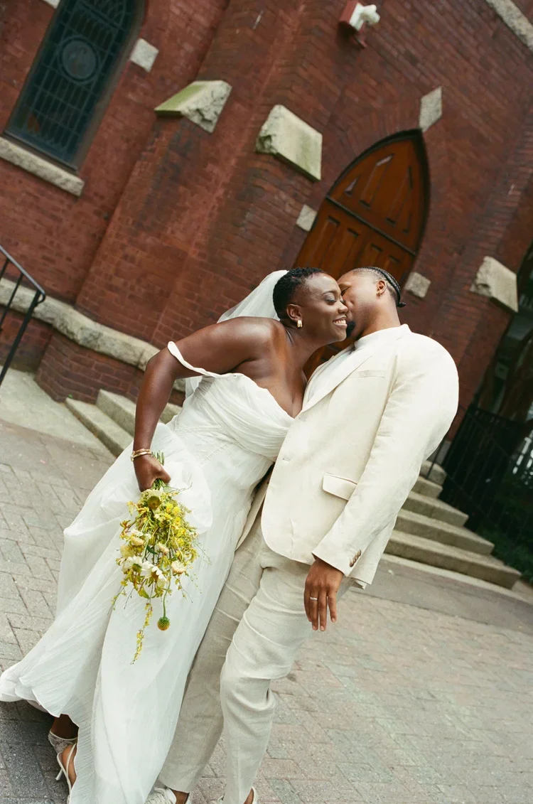 Couple kissing in front of chapel, by a wedding photographer in raleigh nc