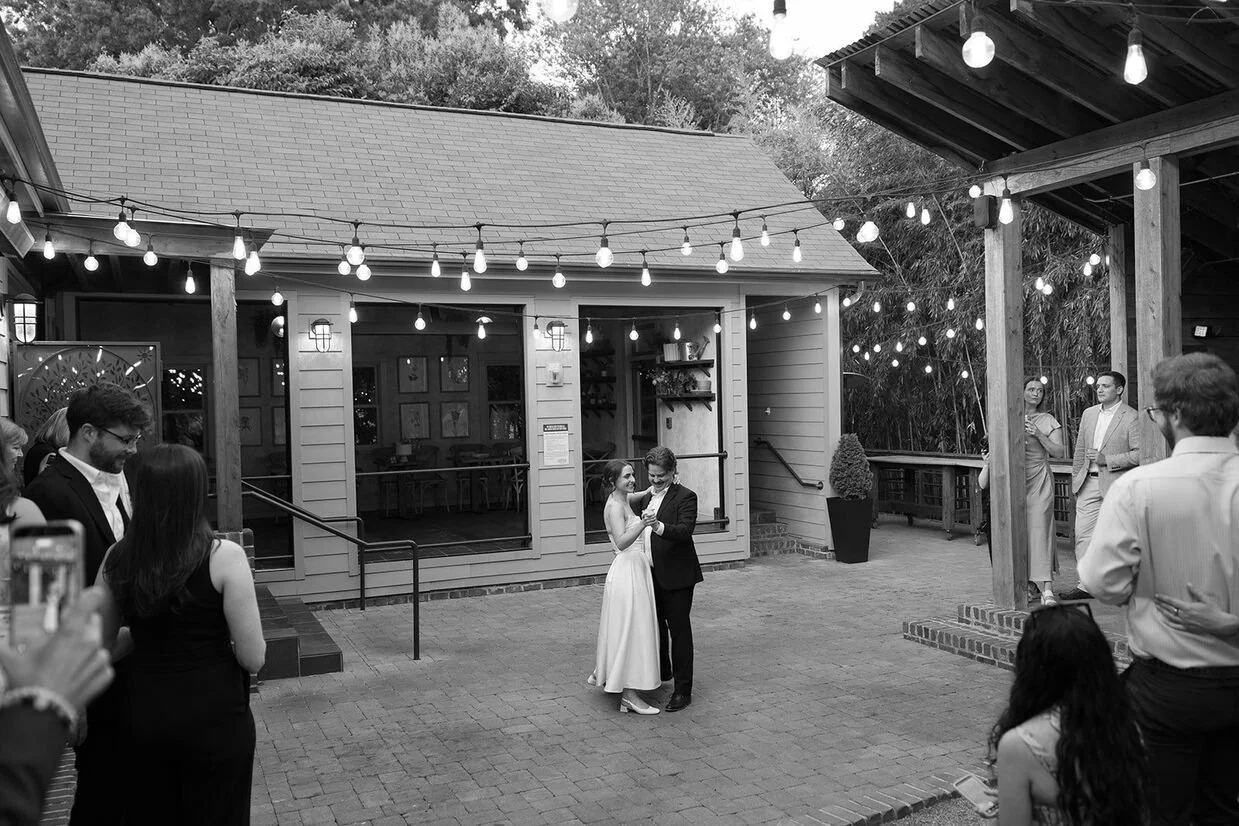 Couple having a romantic first dance at The Goodyear House outdoor patio with string lights.