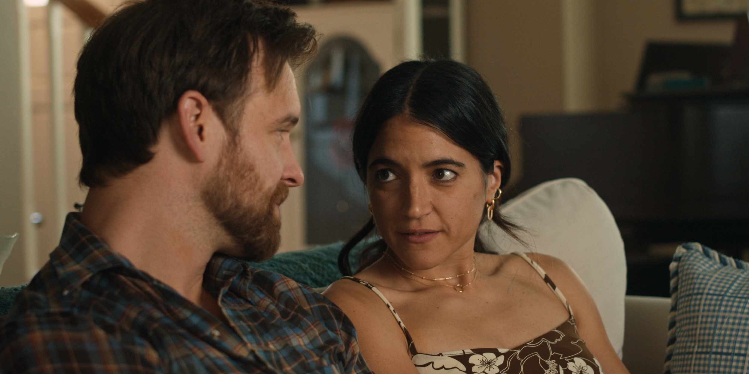 A man and a woman sit along side each other on a couch