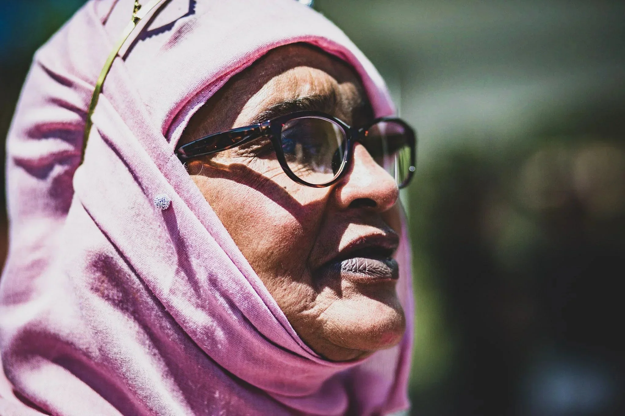 A woman in a pink hijab and glasses