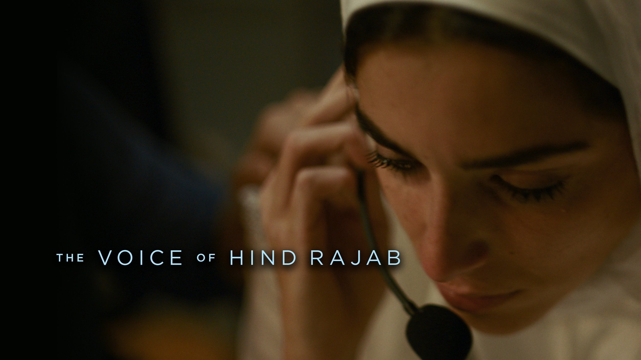 A woman in a hijab listens to her headset