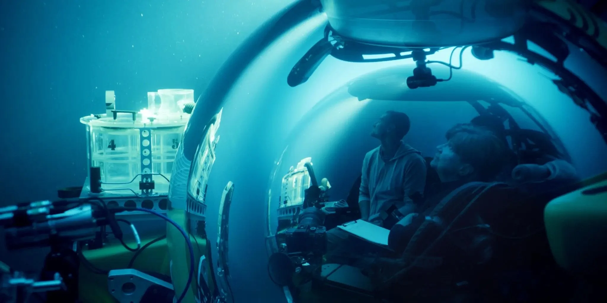 Divers sit in the viewing chamber of a submarine